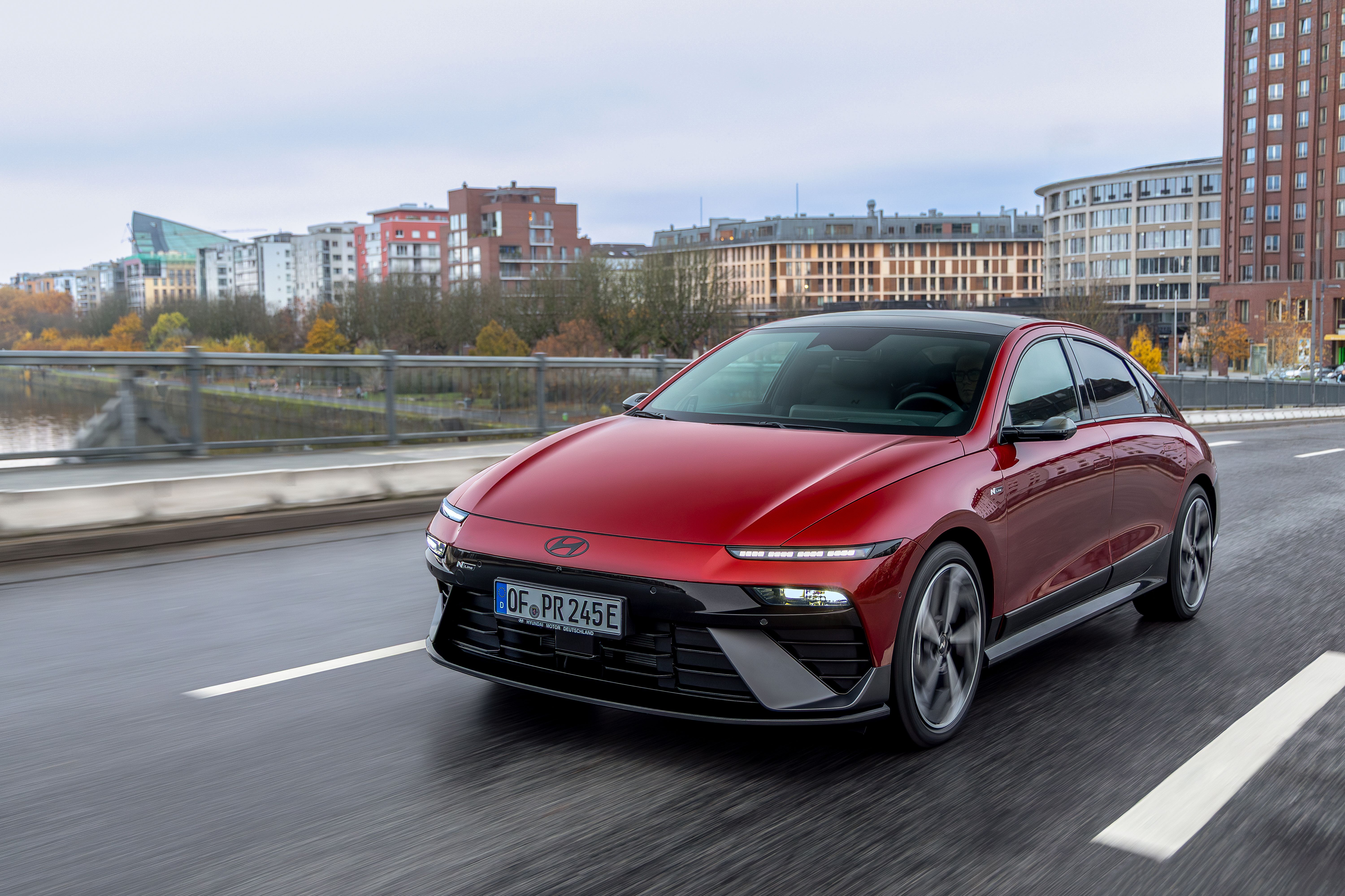 Ein roter Hyundai Ioniq 6 fährt auf einer Straße in einer Stadt.