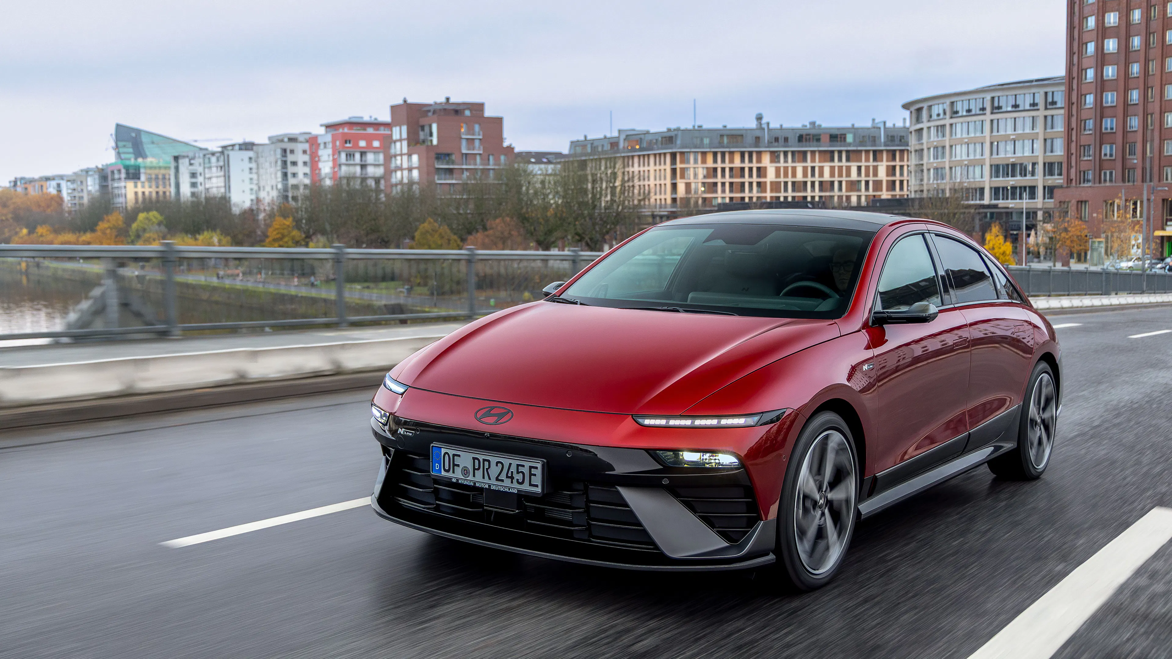 Ein roter Hyundai Ioniq 6 fährt auf einer Straße in einer Stadt.