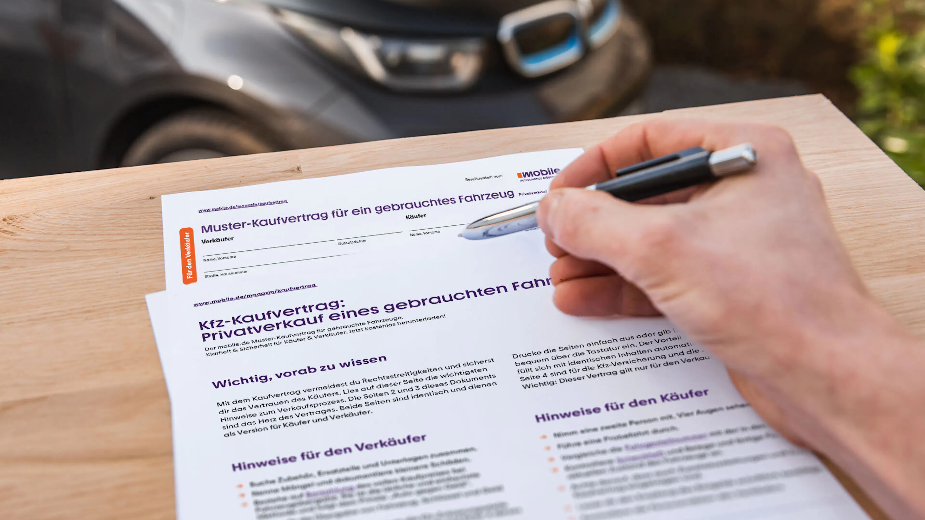 Eine Person füllt einen Kfz-Kaufvertrag für einen Privatverkauf aus.