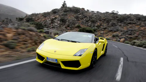 Ein gelber Lamborghini Gallardo Spyder fährt auf einer Landstraße.