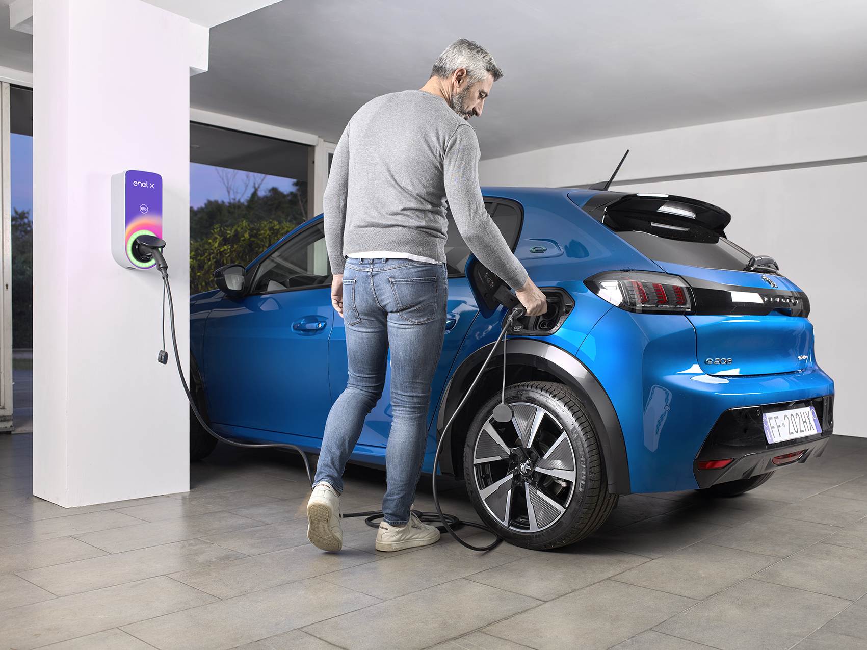 Mann lädt sein Autos zu Hause mit einer Wallbox