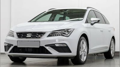 Ein weißer Seat Leon TGI Sportstourer steht in einem Raum mit weißen Wänden und grauem Boden