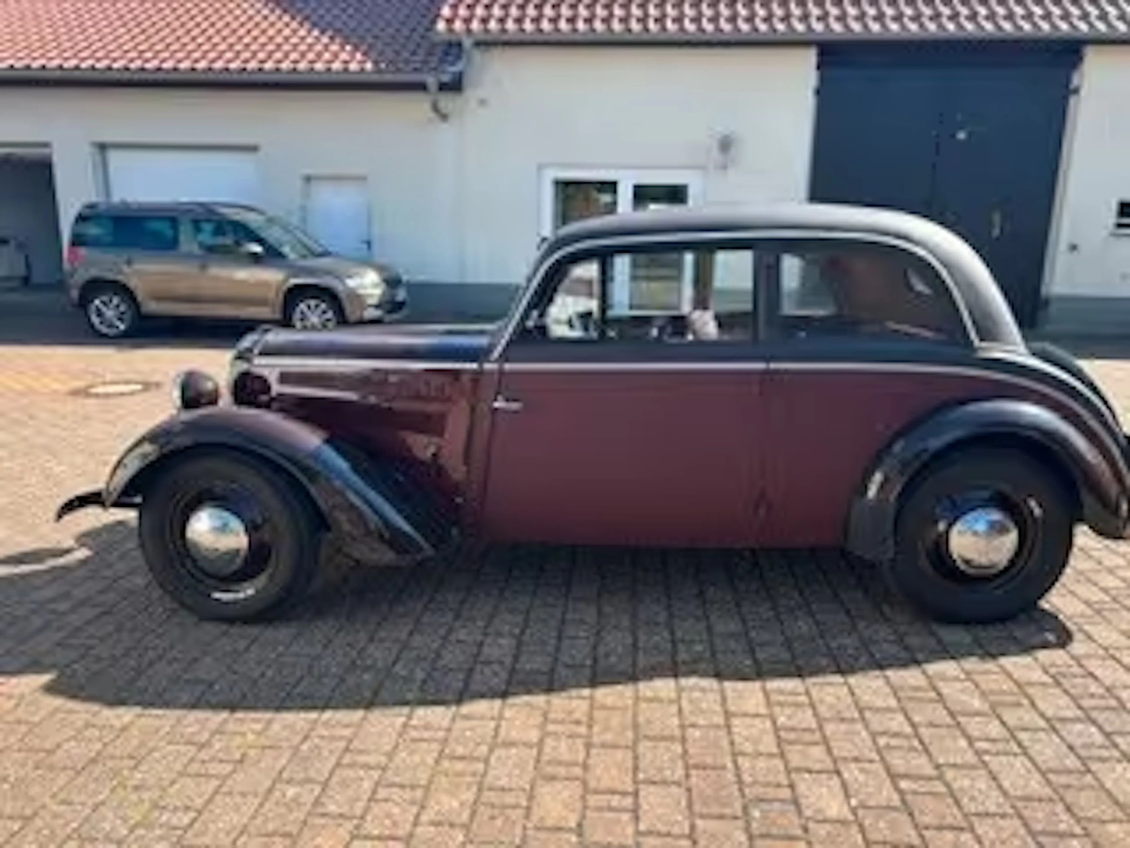 Rot-schwarzer DKW F8 steht auf gepflasterter Einfahrt