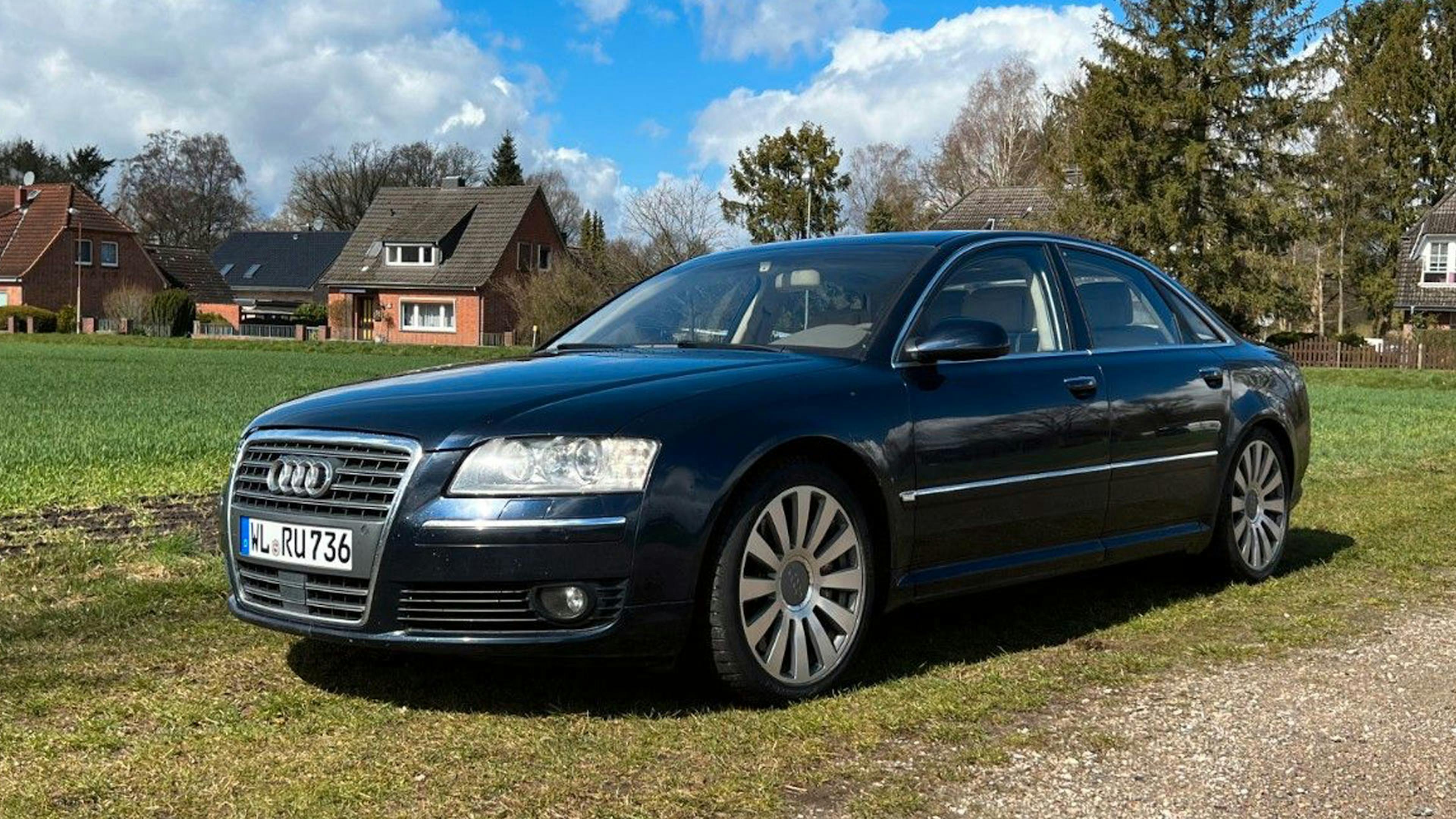 Ein schwarzer Audi A8 steht auf einem Feldweg.