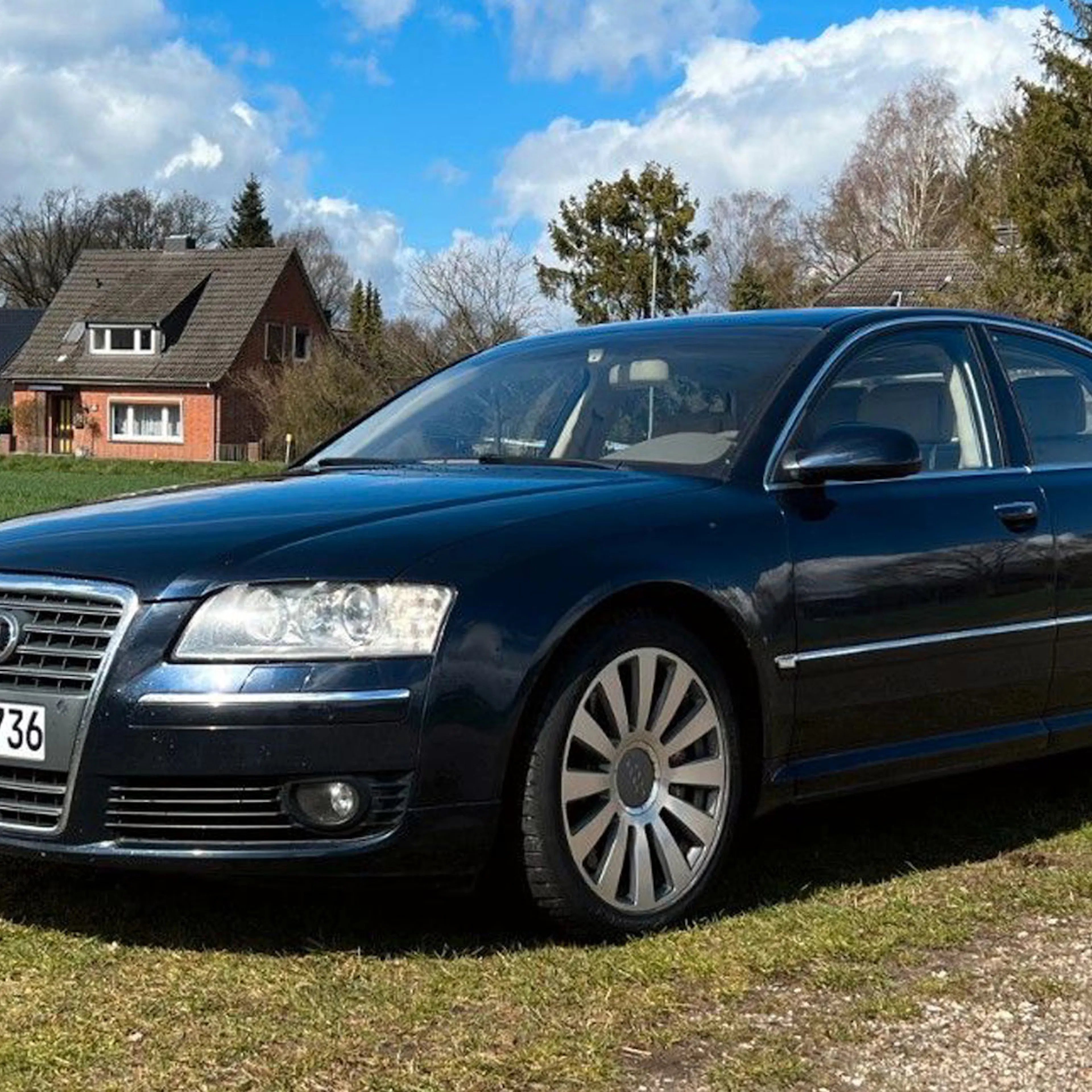 Ein schwarzer Audi A8 steht auf einem Feldweg.