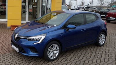 Ein dunkelblauer Renault Clio E-Tech Hybrid steht vor einem Autohaus.