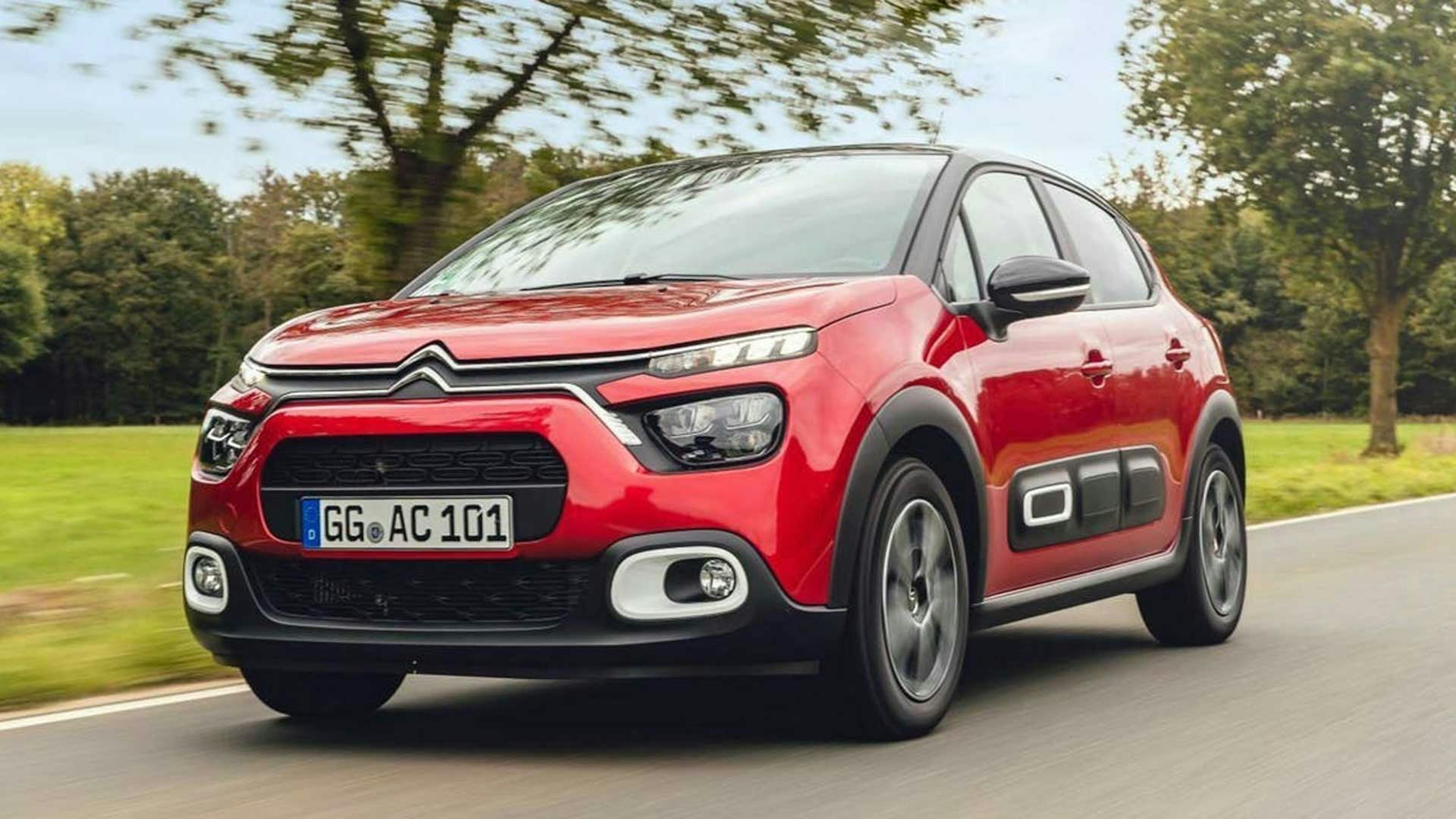 Ein roter Citroën C3 fährt eine Landstraße entlang.