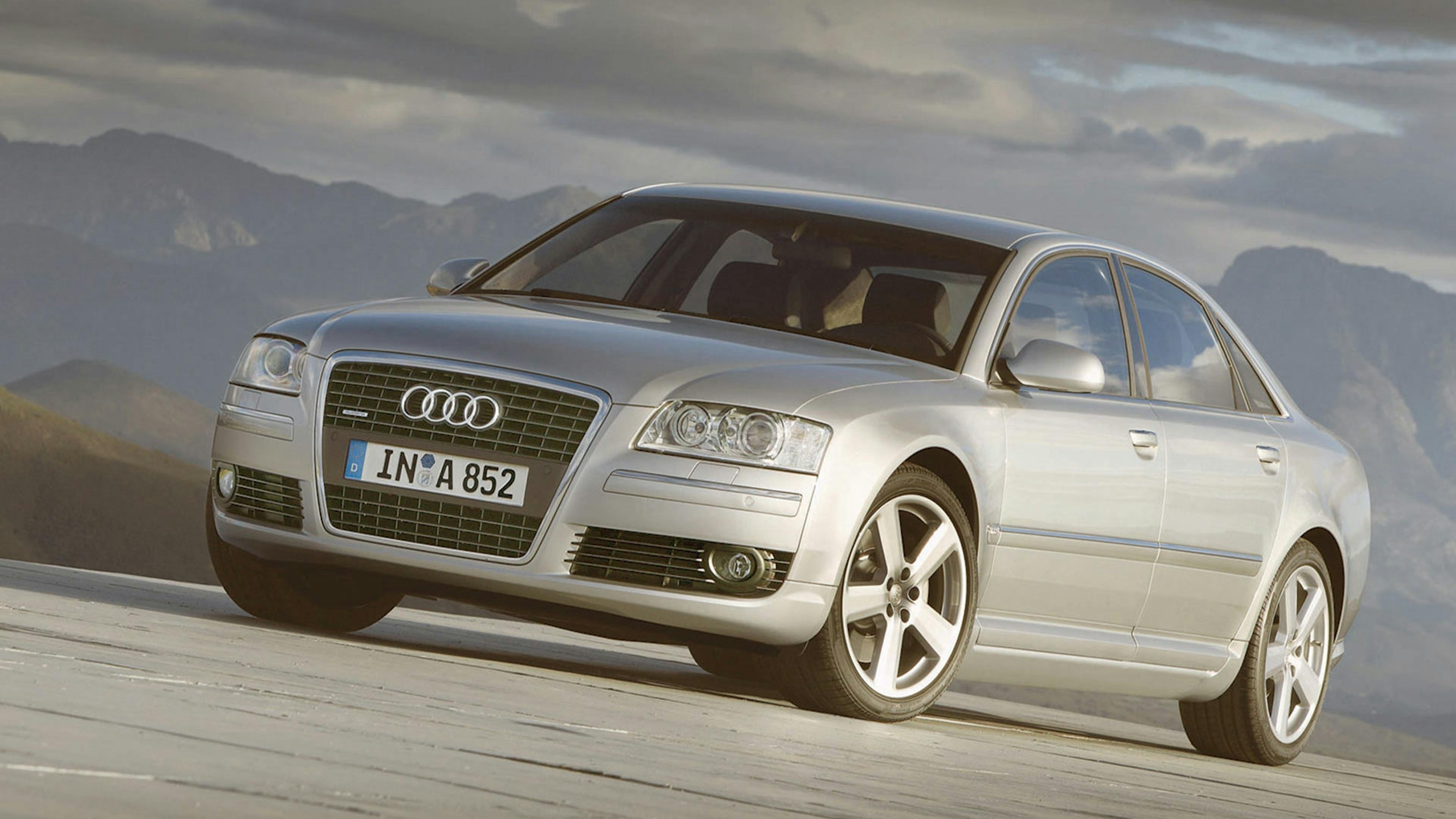 Ein silberner Audi A8 steht vor einer kargen Berglandschaft.