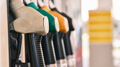 Nahaufnahme von vier eingehakten Tankstutzen an einer Zapfsäule