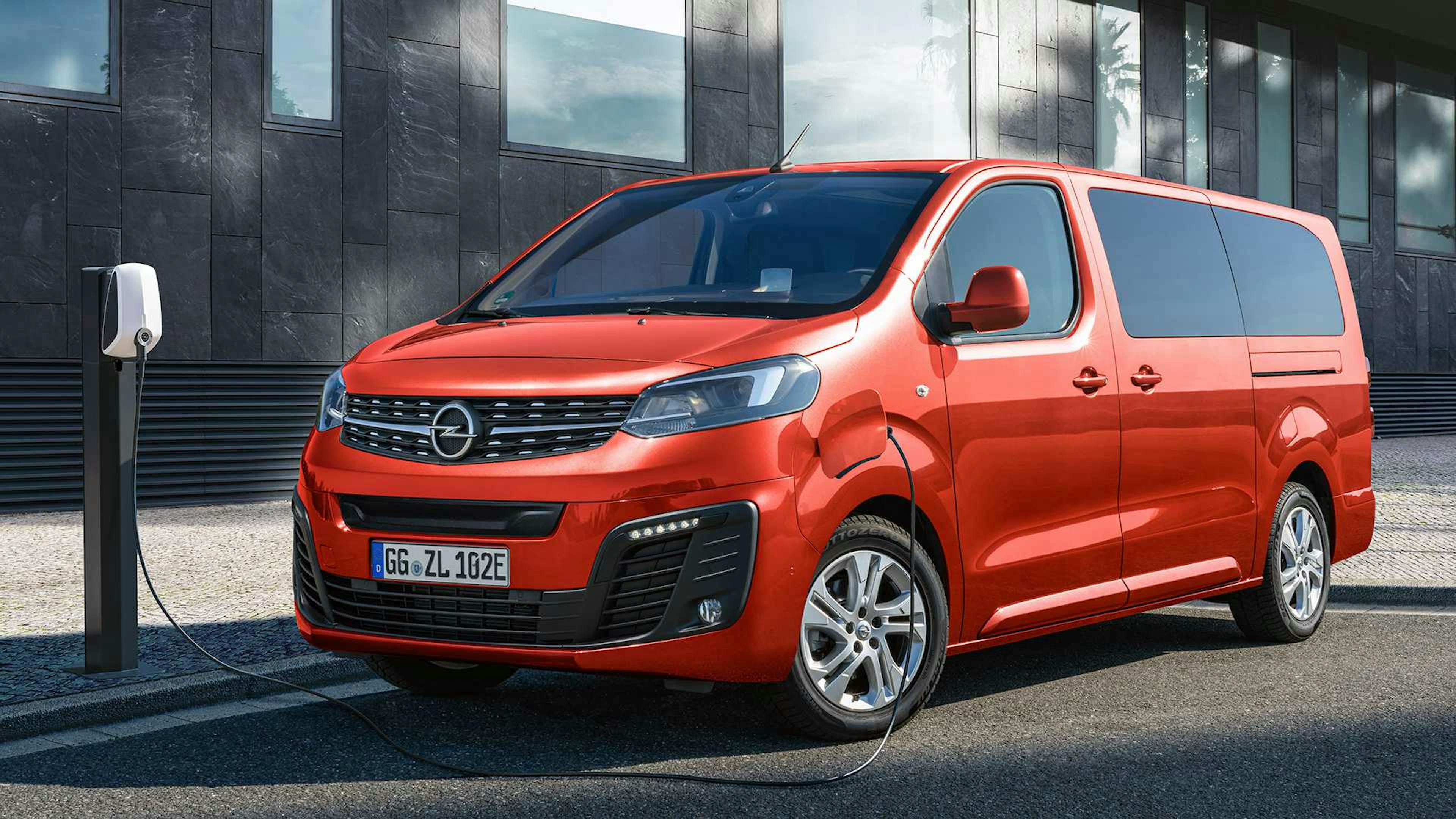 Ein roter Opel Zafira-e Life wird an einer Ladesäule geladen.