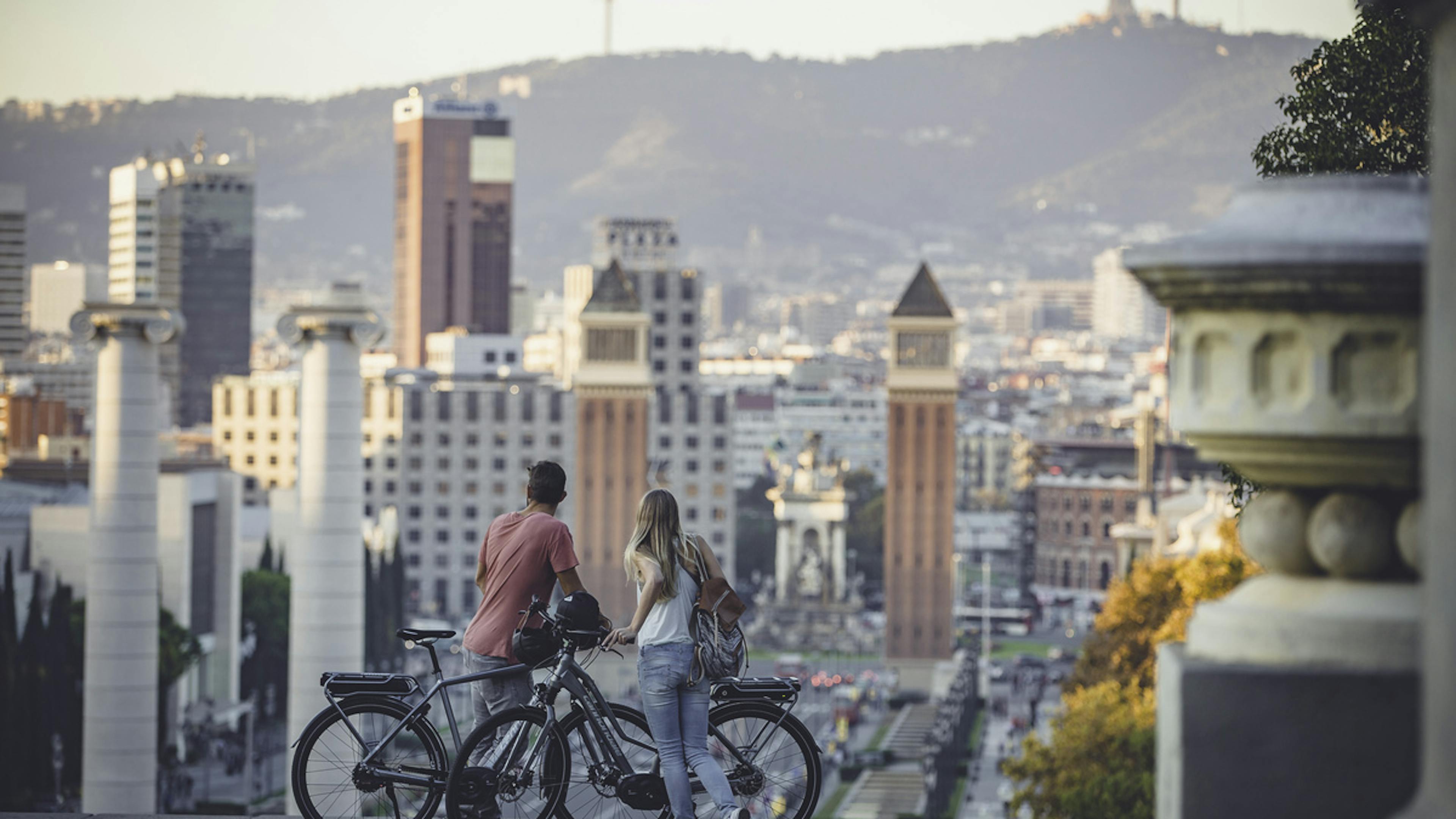 Zwei Menschen mit E-Bikes in einer Großstadt