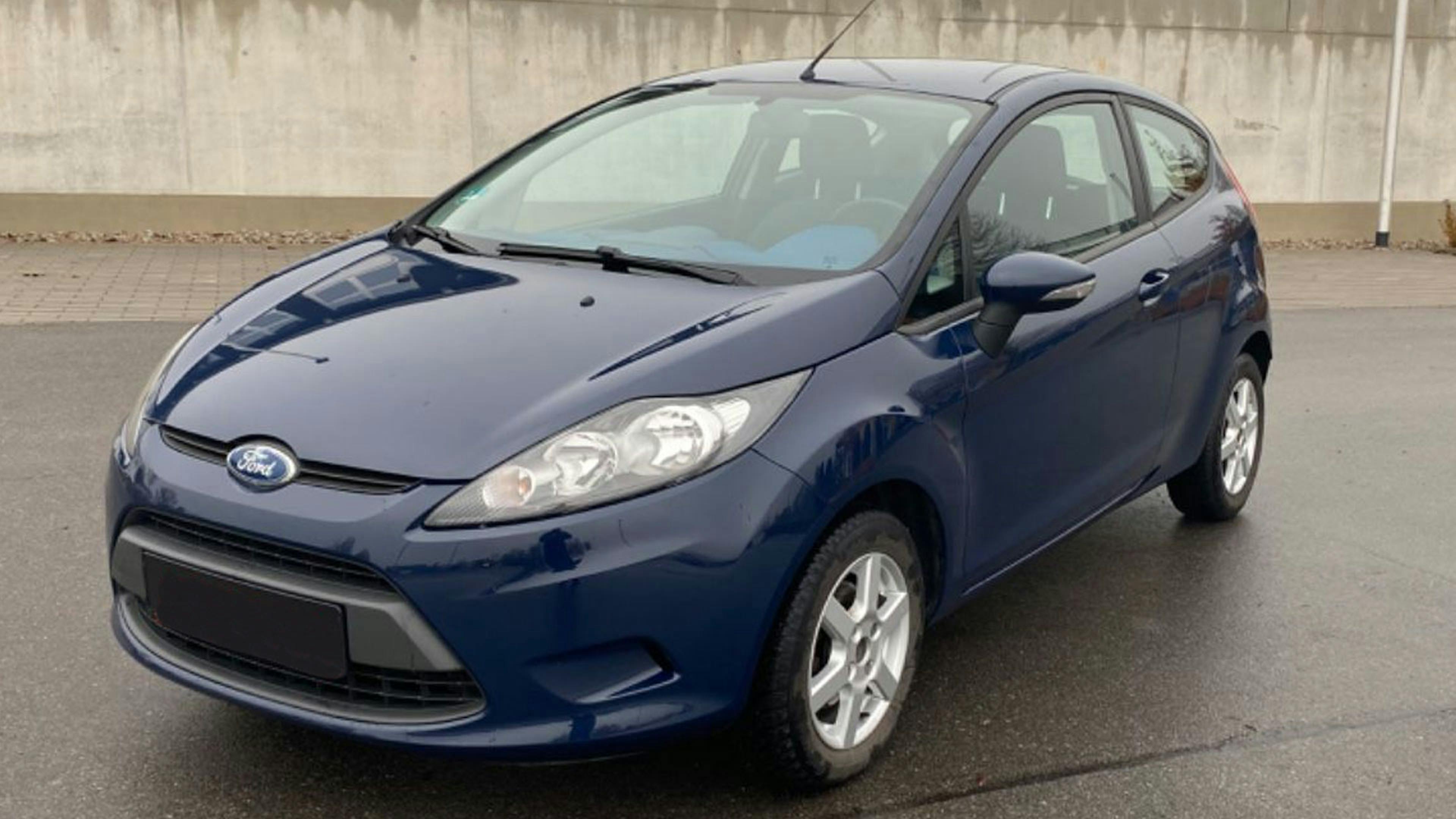 Ein dunkelblauer Ford Fiesta steht auf einem Parkplatz.