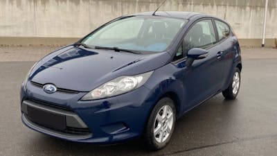 Ein dunkelblauer Ford Fiesta steht auf einem Parkplatz.