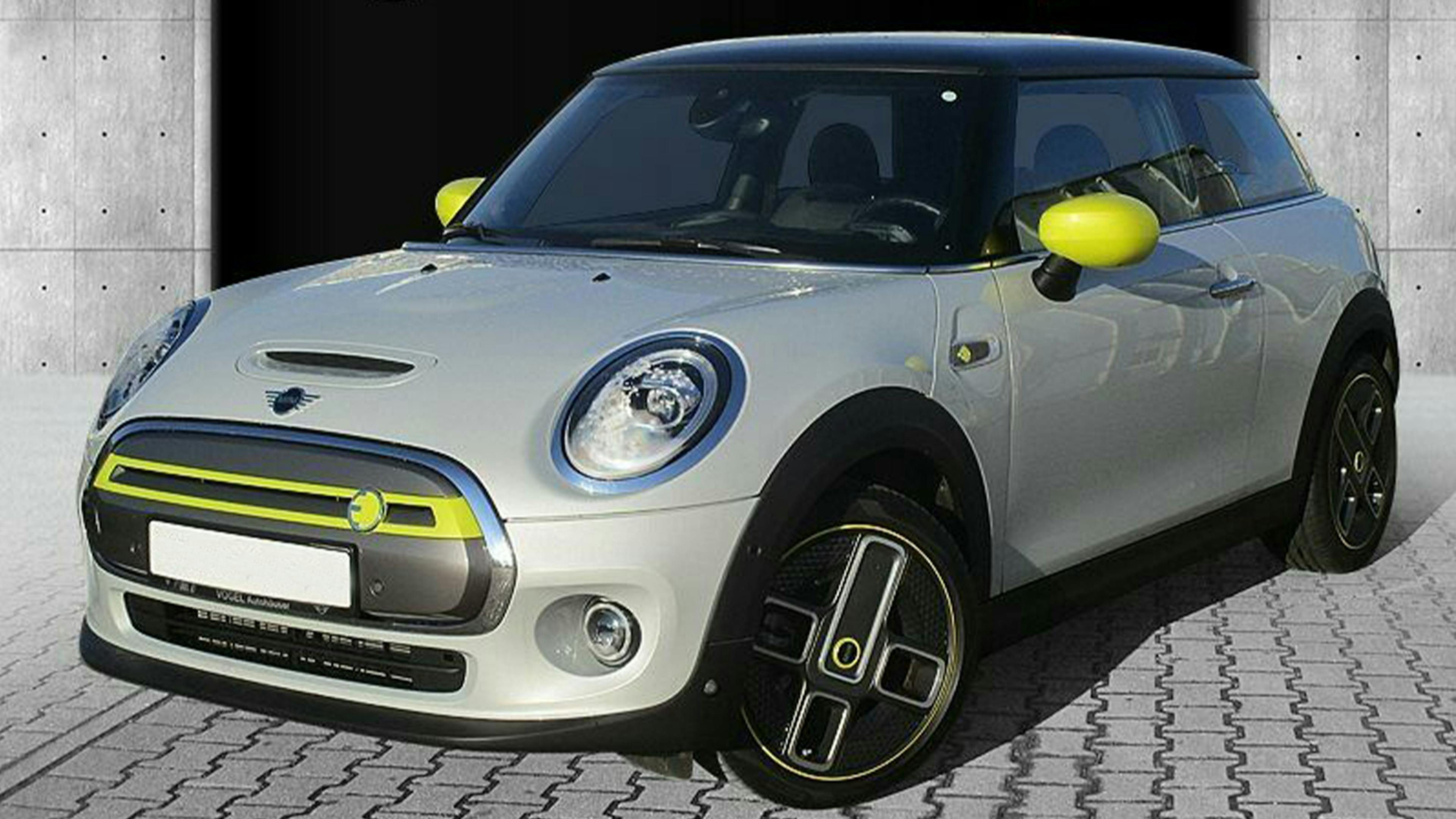 Ein grauer BMW Mini Cooper SE steht vor einem grauen Gebäude.