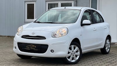 Ein weißer Nissan Micra steht vor einem weißen Haus.