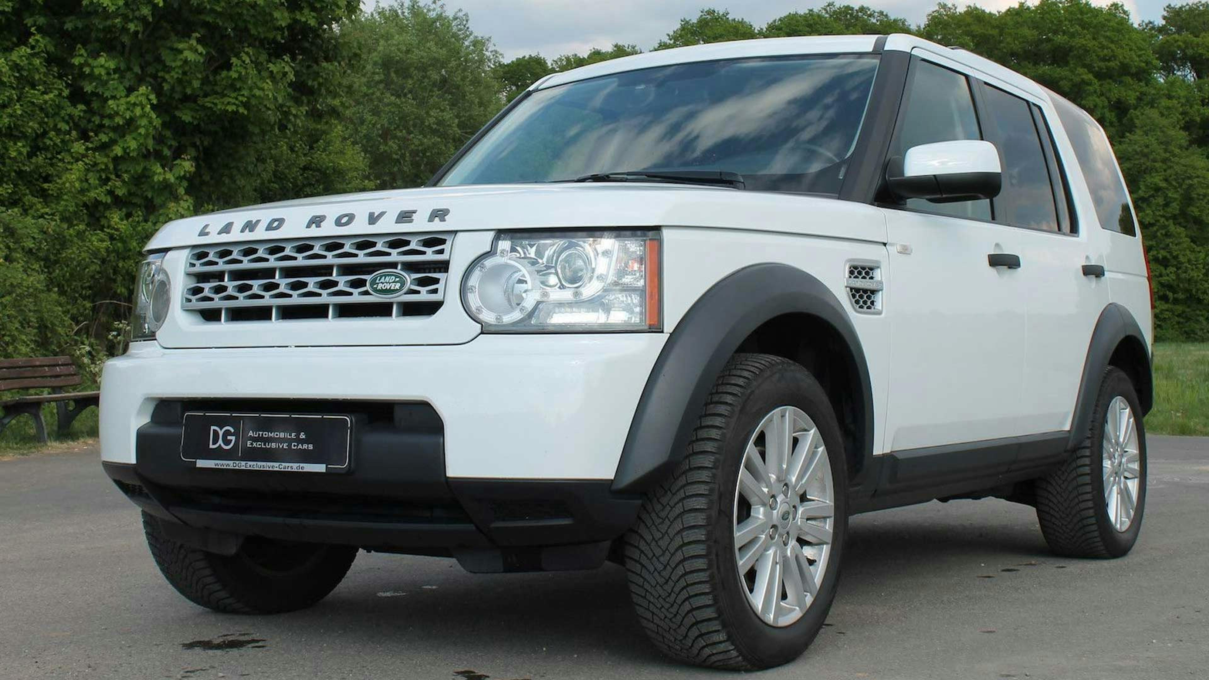 Ein weißer Land Rover Discovery steht auf einem Parkplatz.