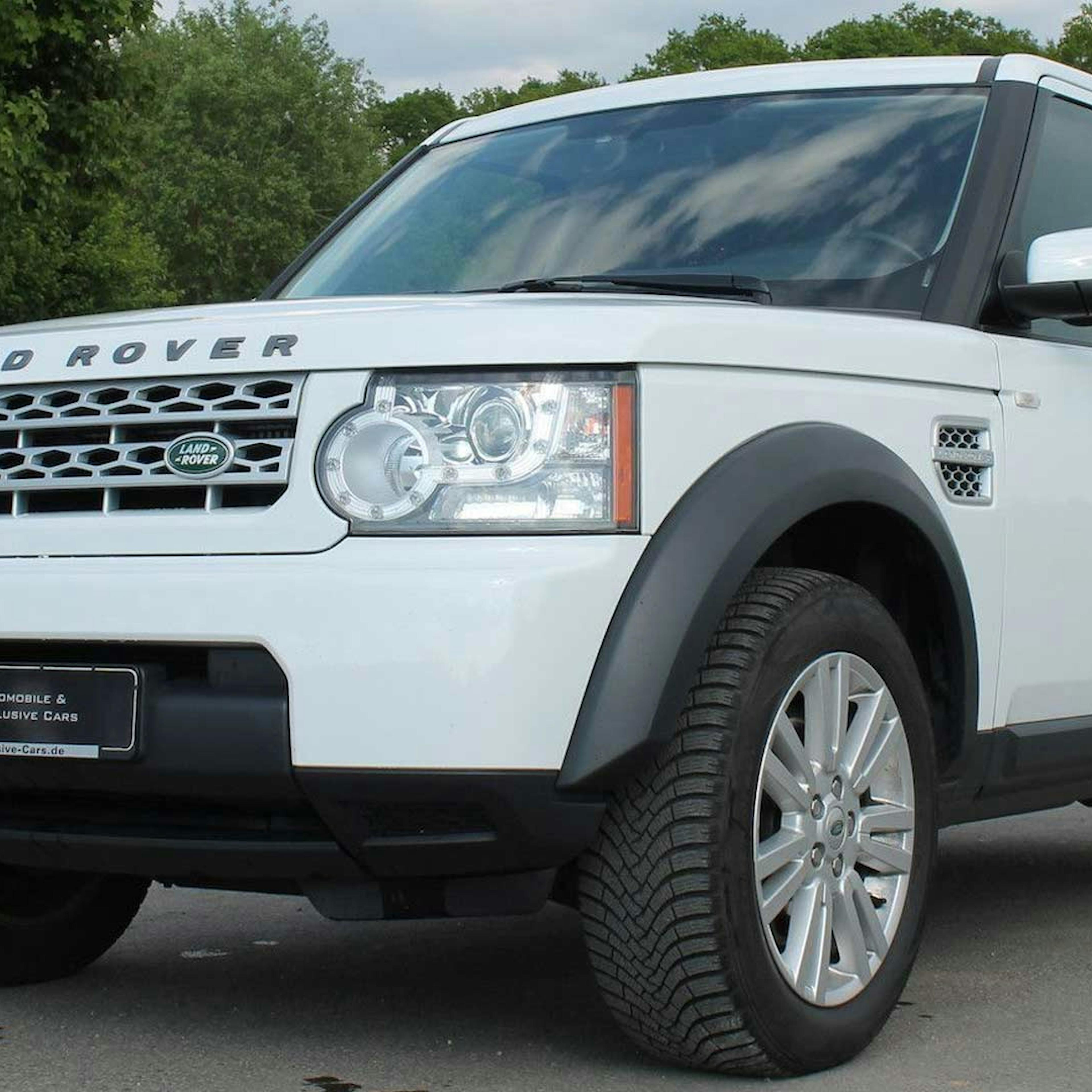 Ein weißer Land Rover Discovery steht auf einem Parkplatz.