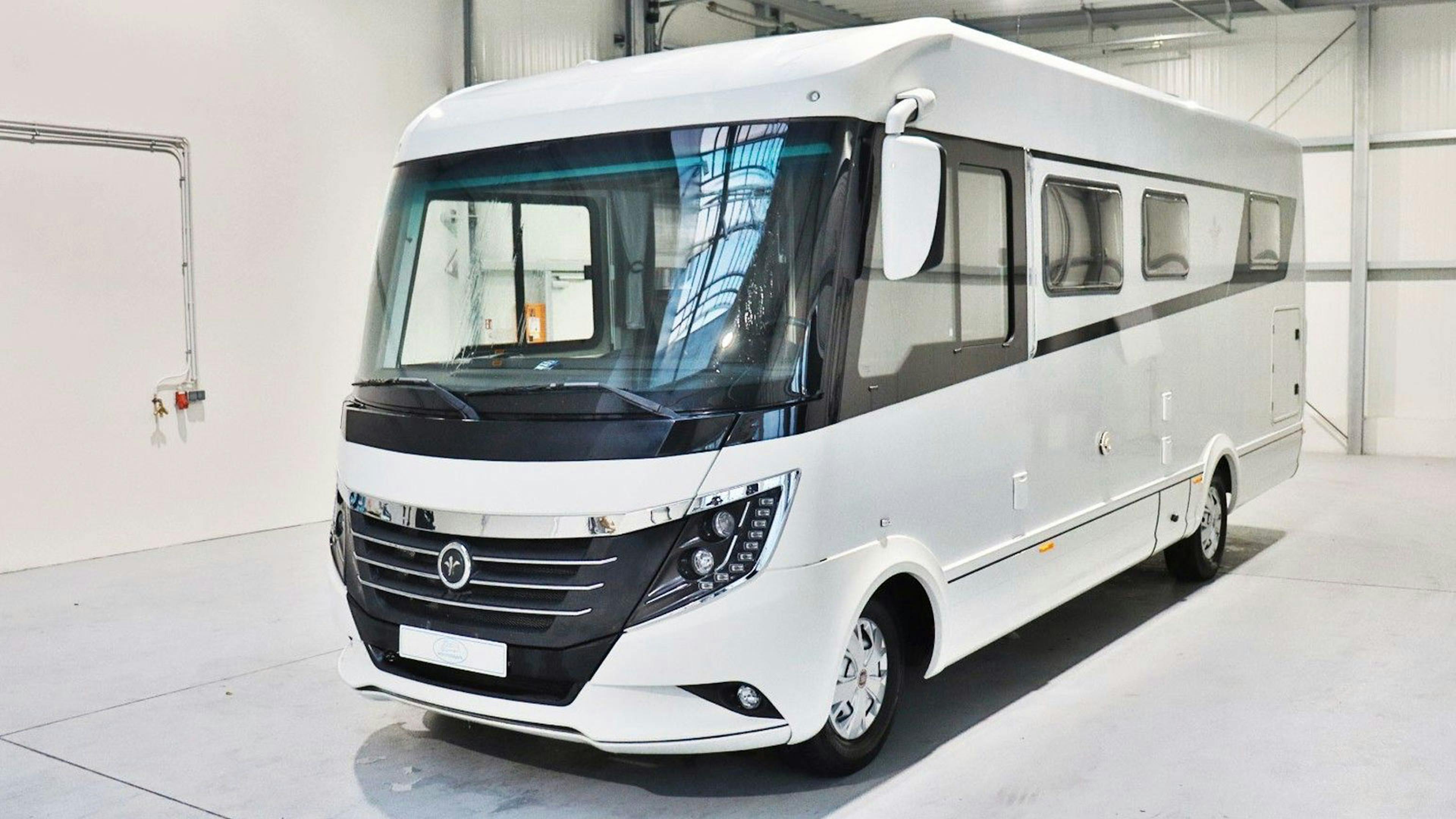 Ein weißes Niesmann + Bischoff Arto Wohnmobil steht in einer hellen Halle.