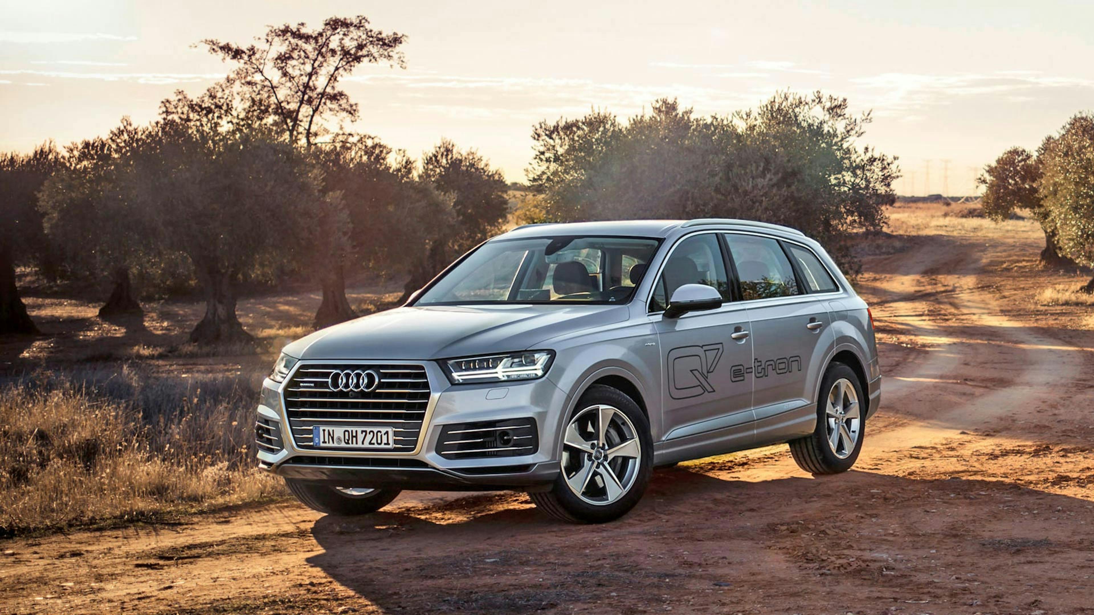 Ein silberner Audi-Q7 3.0 TDI e-tron Diesel-Hybrid fährt durch eine Landschaft