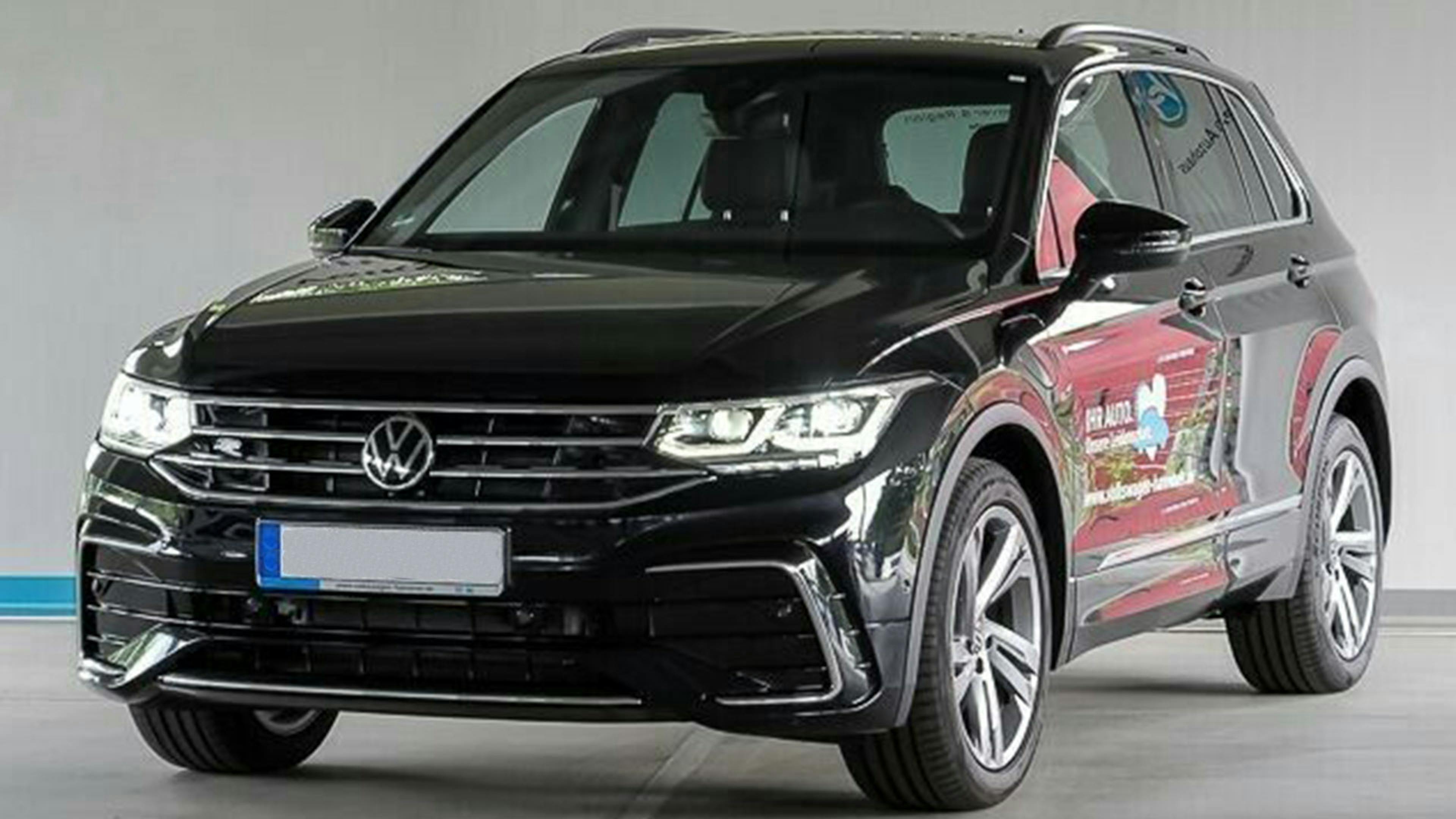 Ein schwarzer VW Tiguan Hybrid-SUV steht vor einer grauen Wand