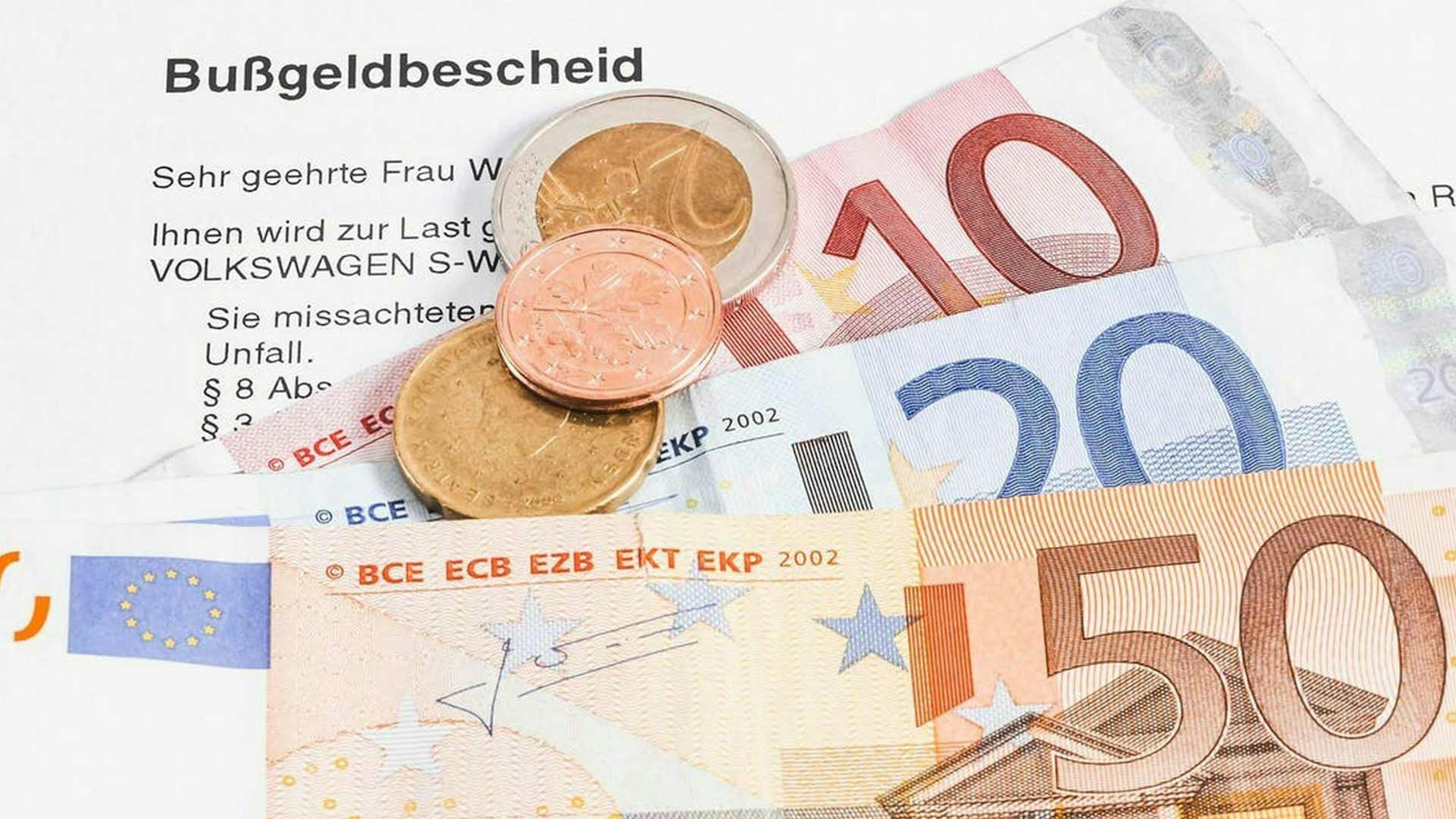 Stillleben mit einem Bußgeldbescheid, Euro-Scheinen und Euro-Münzen.