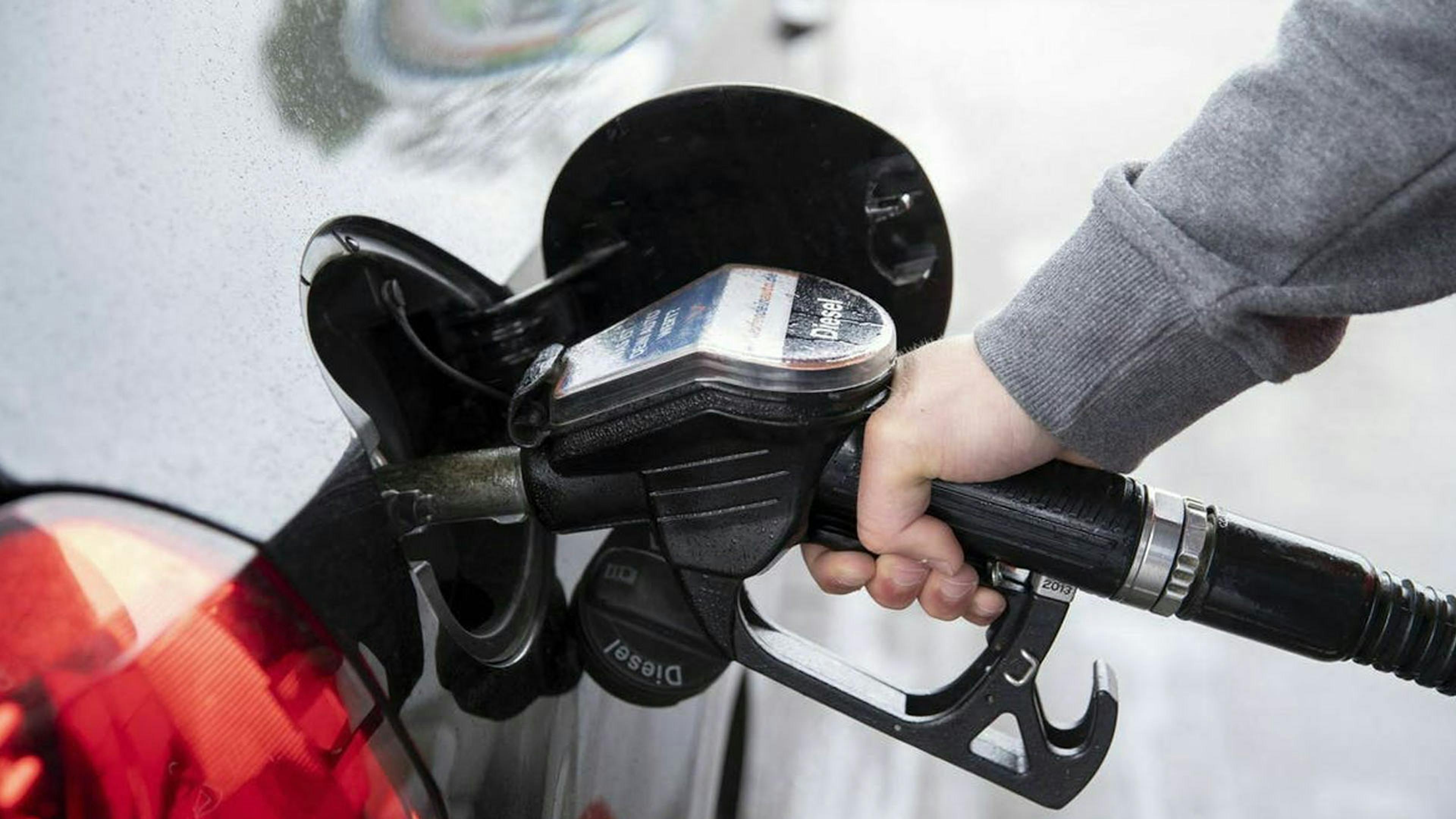 Ein dunkler Pkw wird an einer Zapfsäule mit Diesel betankt.