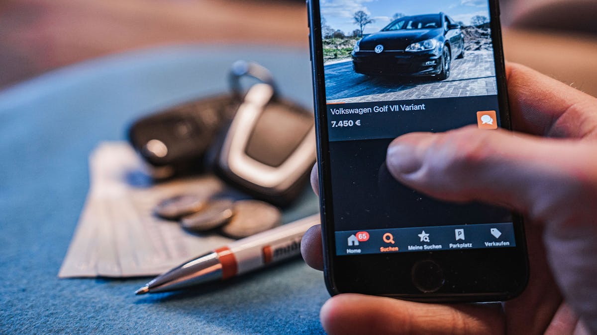 Blick auf ein Smartphone-Display, das eine Pkw-Verkaufsanzeige auf mobile.de zeigt.