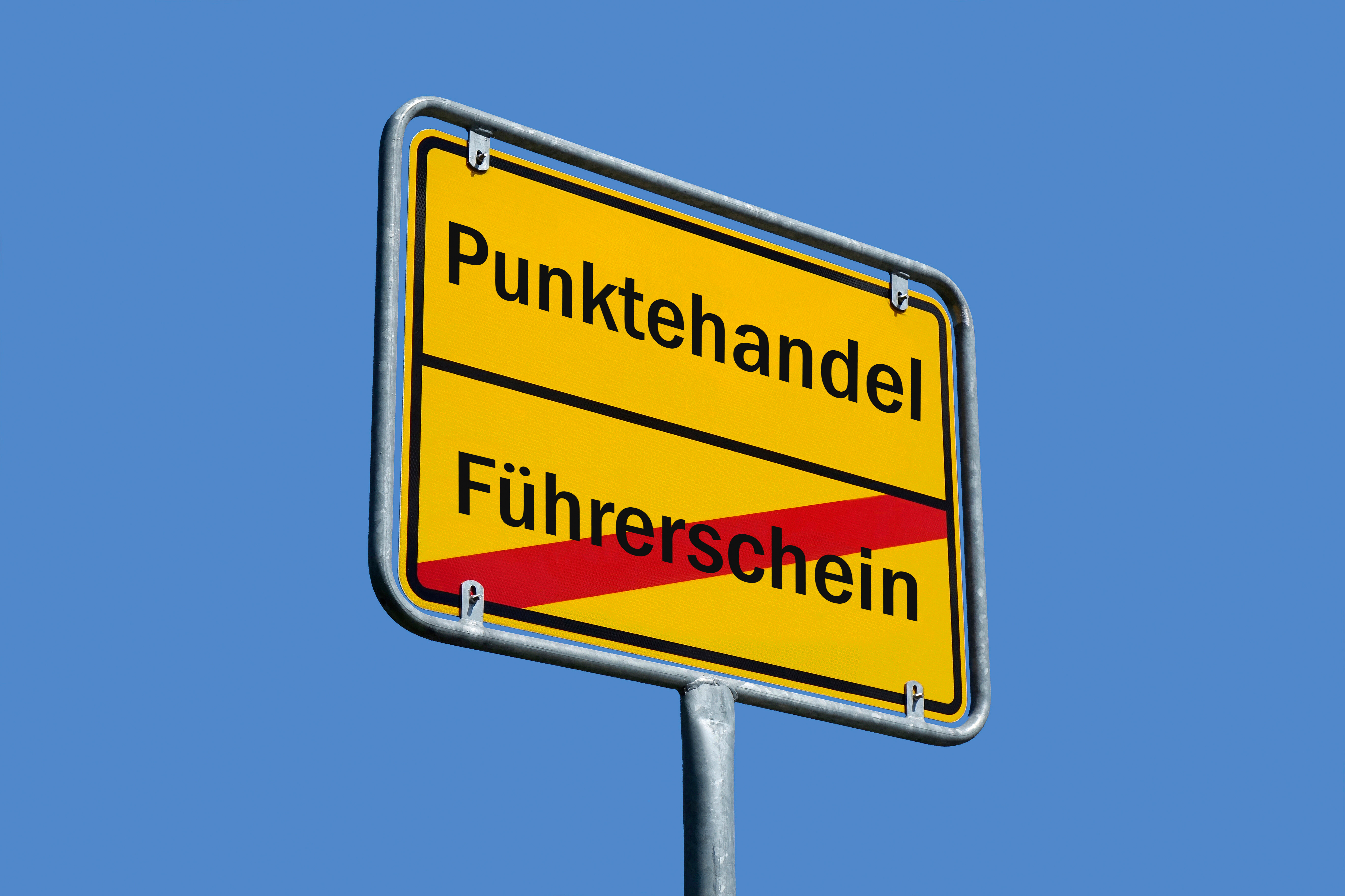 Auf einem Ortsschild stehen die Schriftzüge Punktehandel und Führerschein.