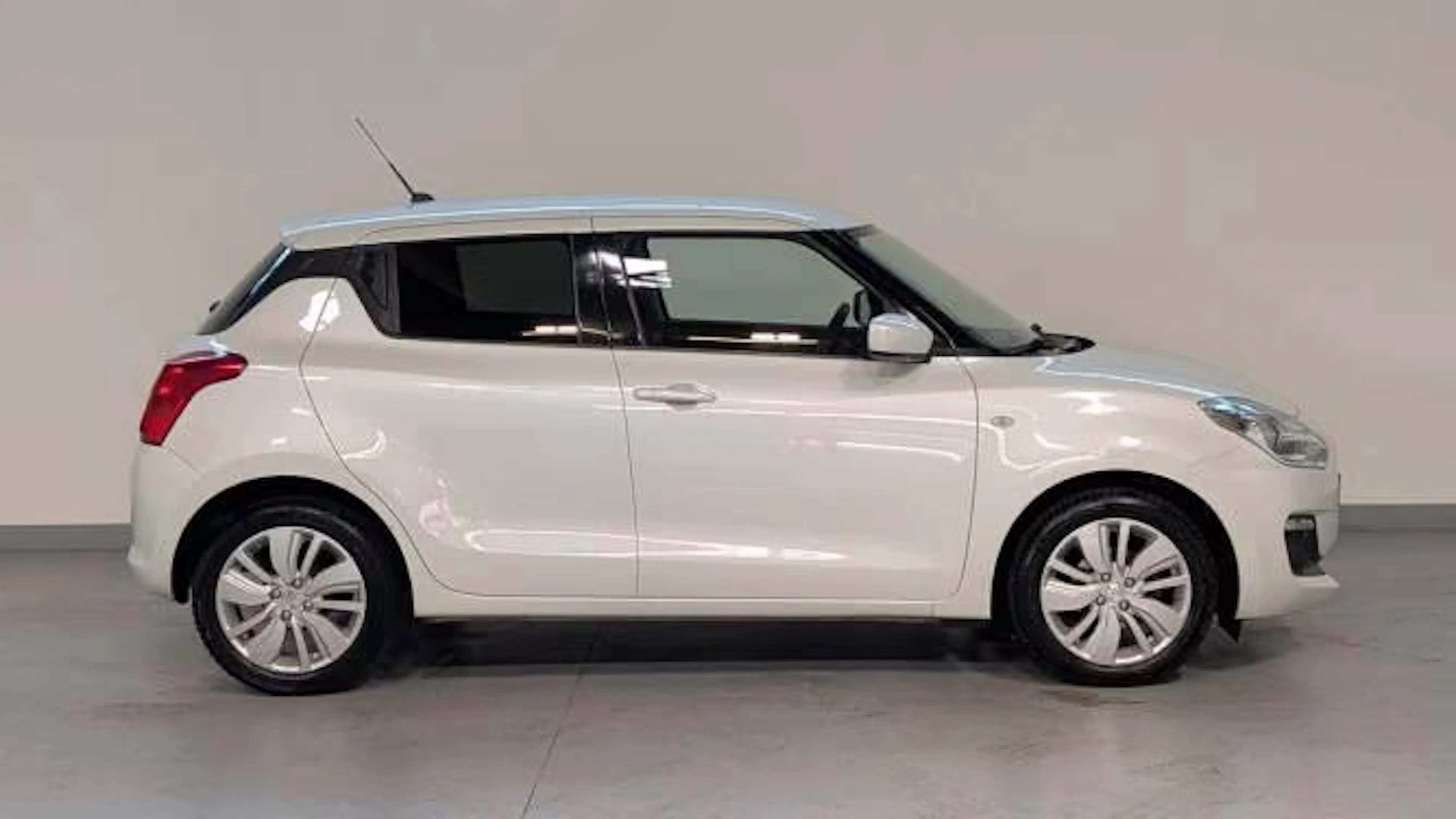 Ein weißer Suzuki Swift steht auf einer Präsentationsfläche.