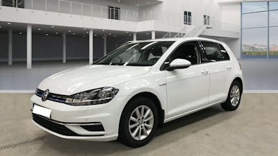 Ein weißer VW Golf TGI mit CNG-Antrieb steht vor einem weißen Gebäude mit Glasfront.