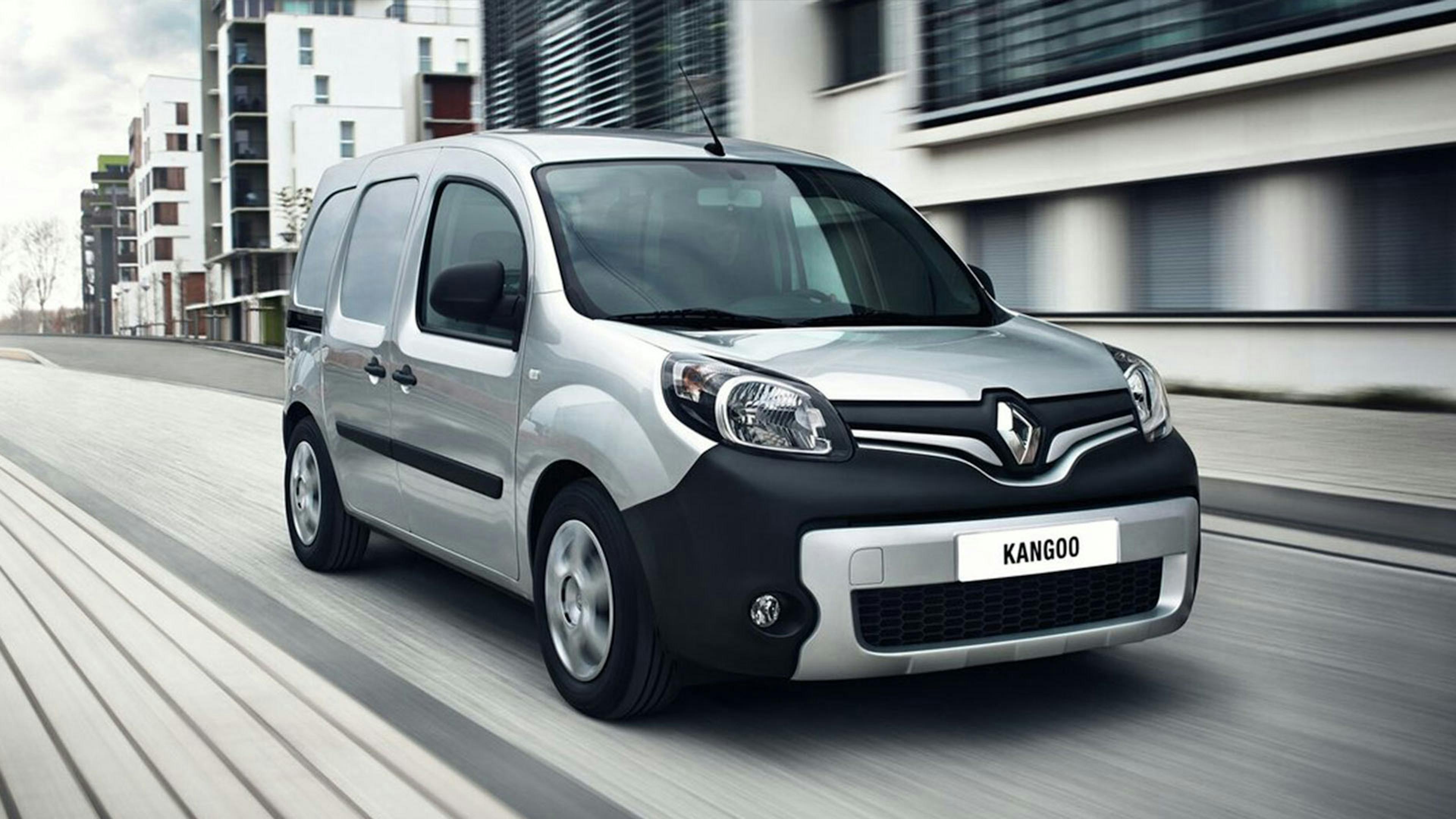 Ein silberner Renault Kangoo fährt durch eine urbane Kulisse.