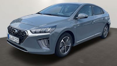 Ein blau-grauer Hyundai Ioniq Hybrid steht vor einer weißen Wand.