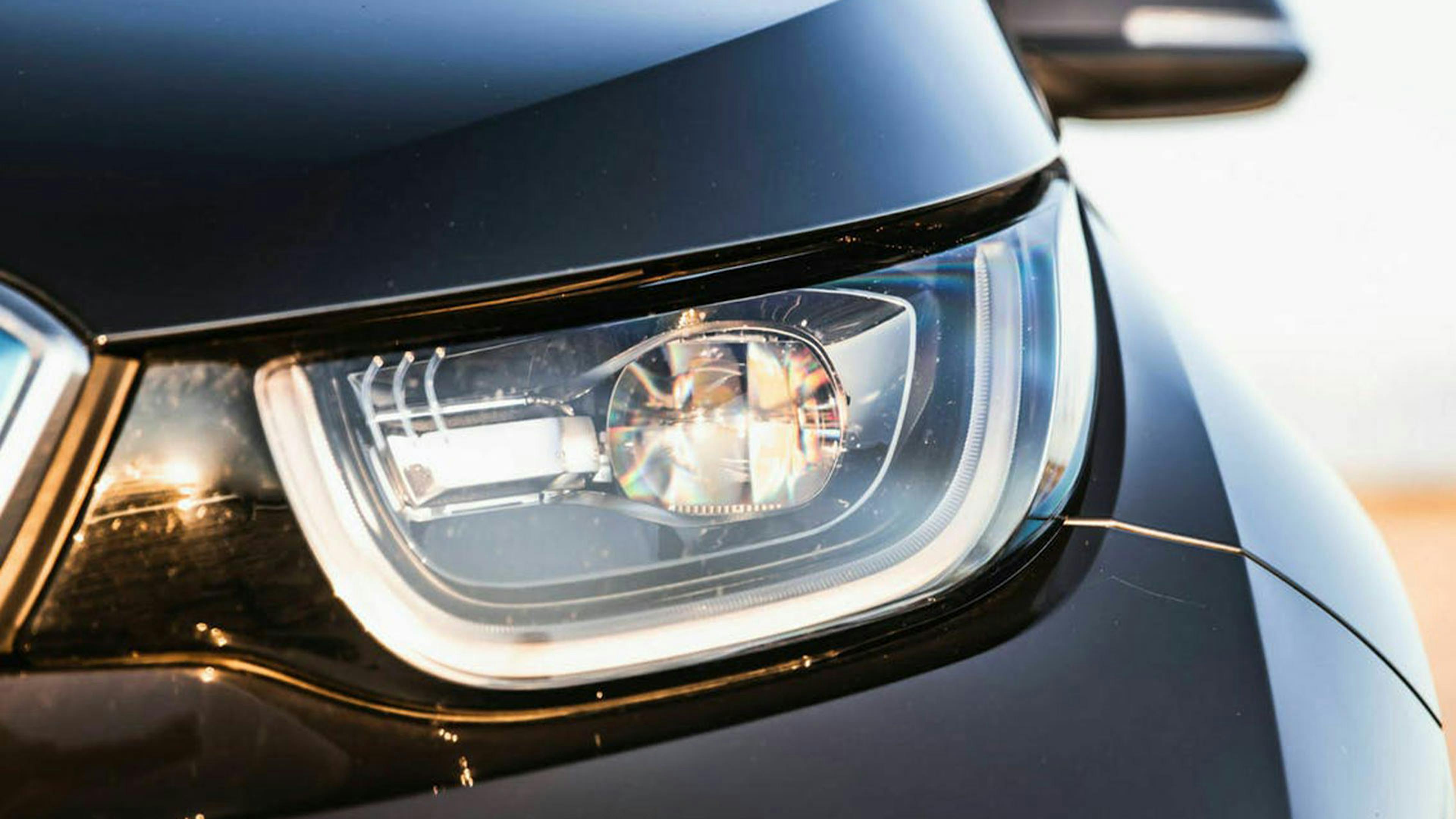 Nahaufnahme des Scheinwerfers eines schwarzen Pkw