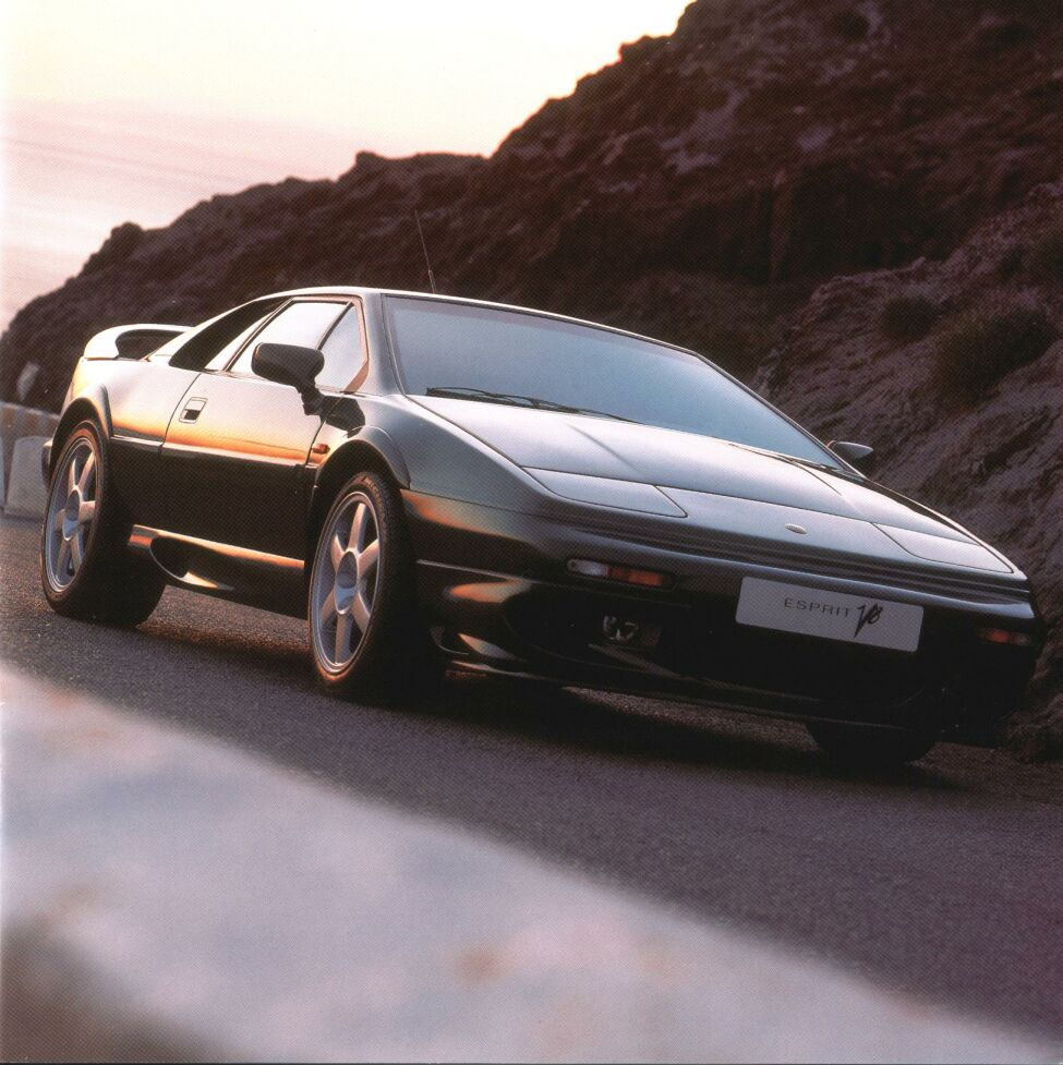 Ein schwarzer Lotus Esprit V8 fährt auf einer Landstraße.