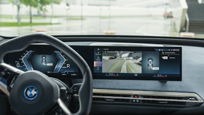 Blick in das Cockpit eines BMW iX mit eingeschaltetem Parkassistenzsystem