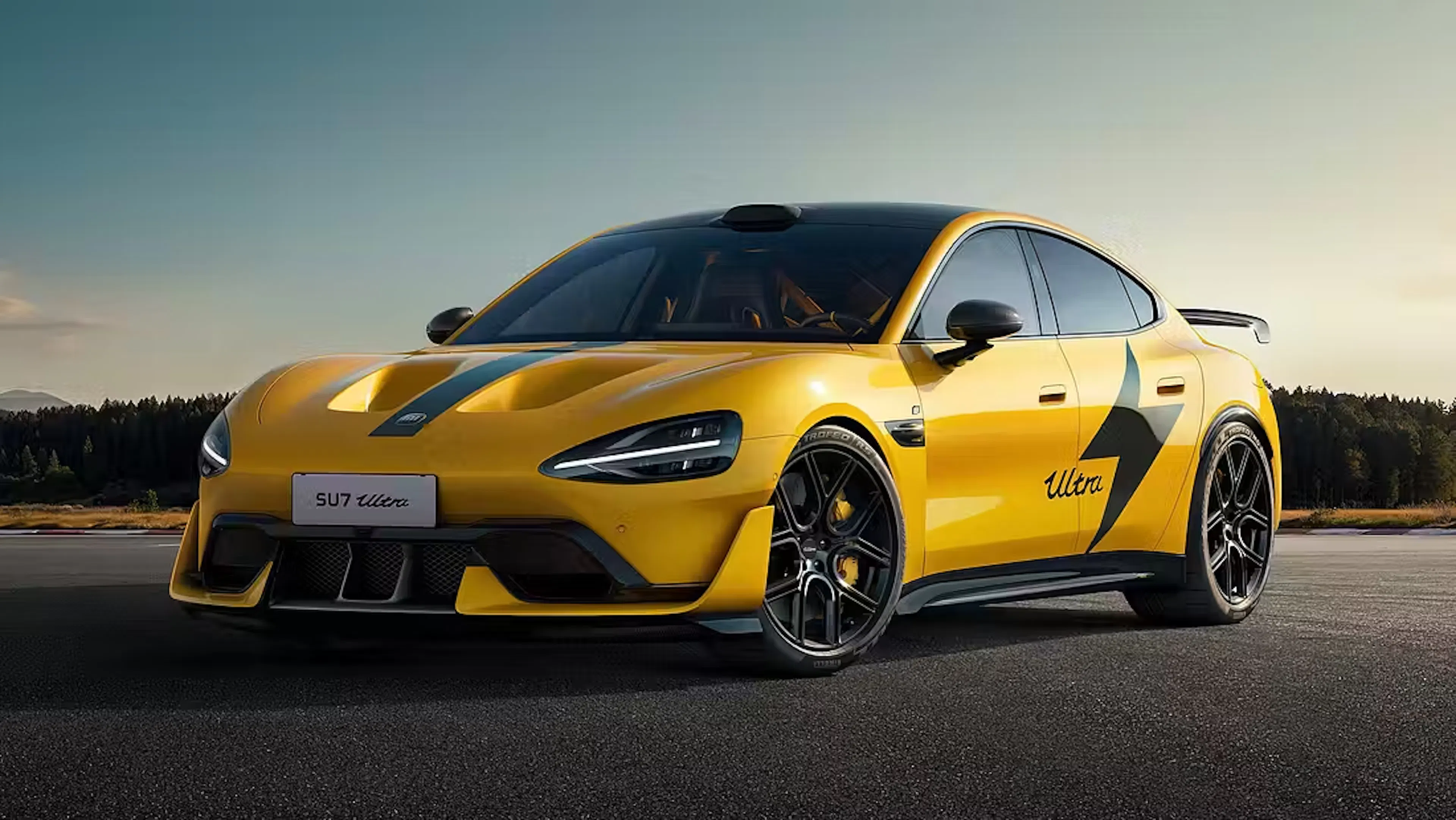 Xiaomi SU7 Ultra in Gelb mit schwarzem Racing-Dekor und „Ultra"-Schriftzug, Frontansicht schräg von vorne auf einem Parkplatz.