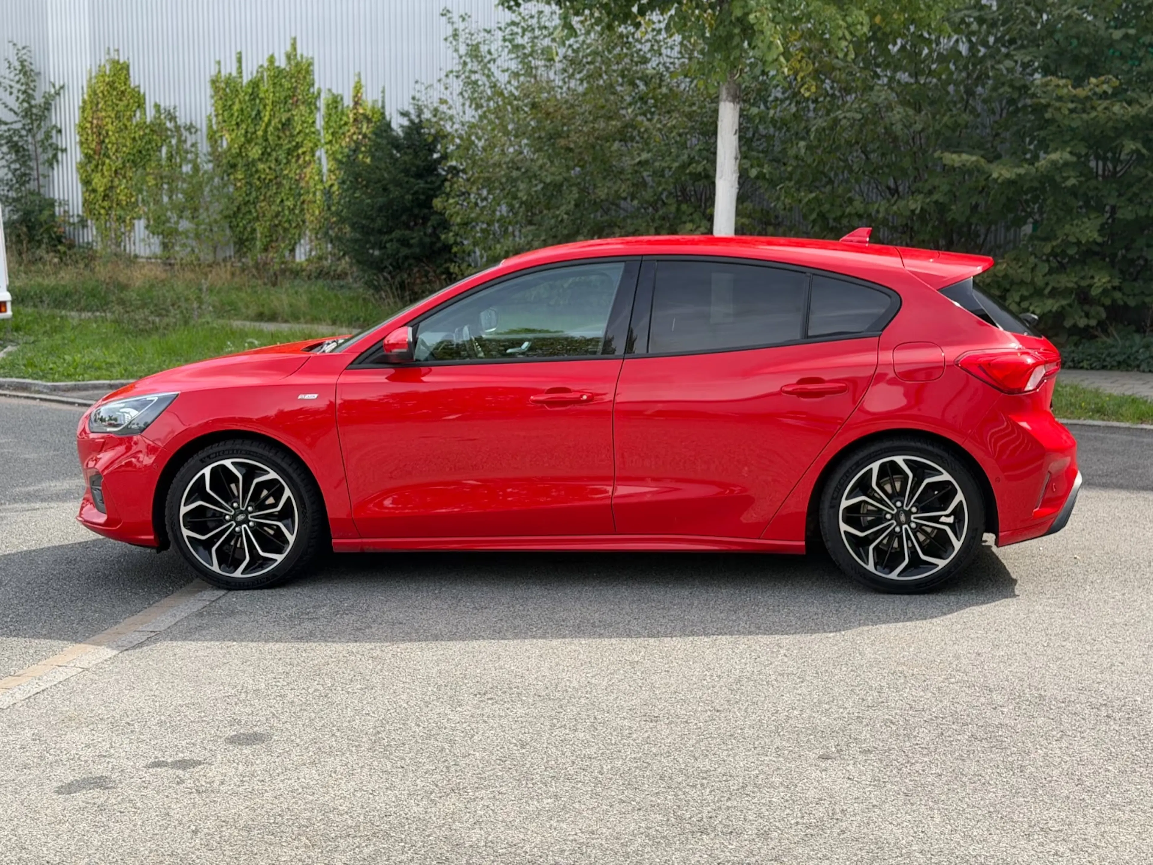 Ein roter Ford Focus steht auf einer befestigten Fläche.