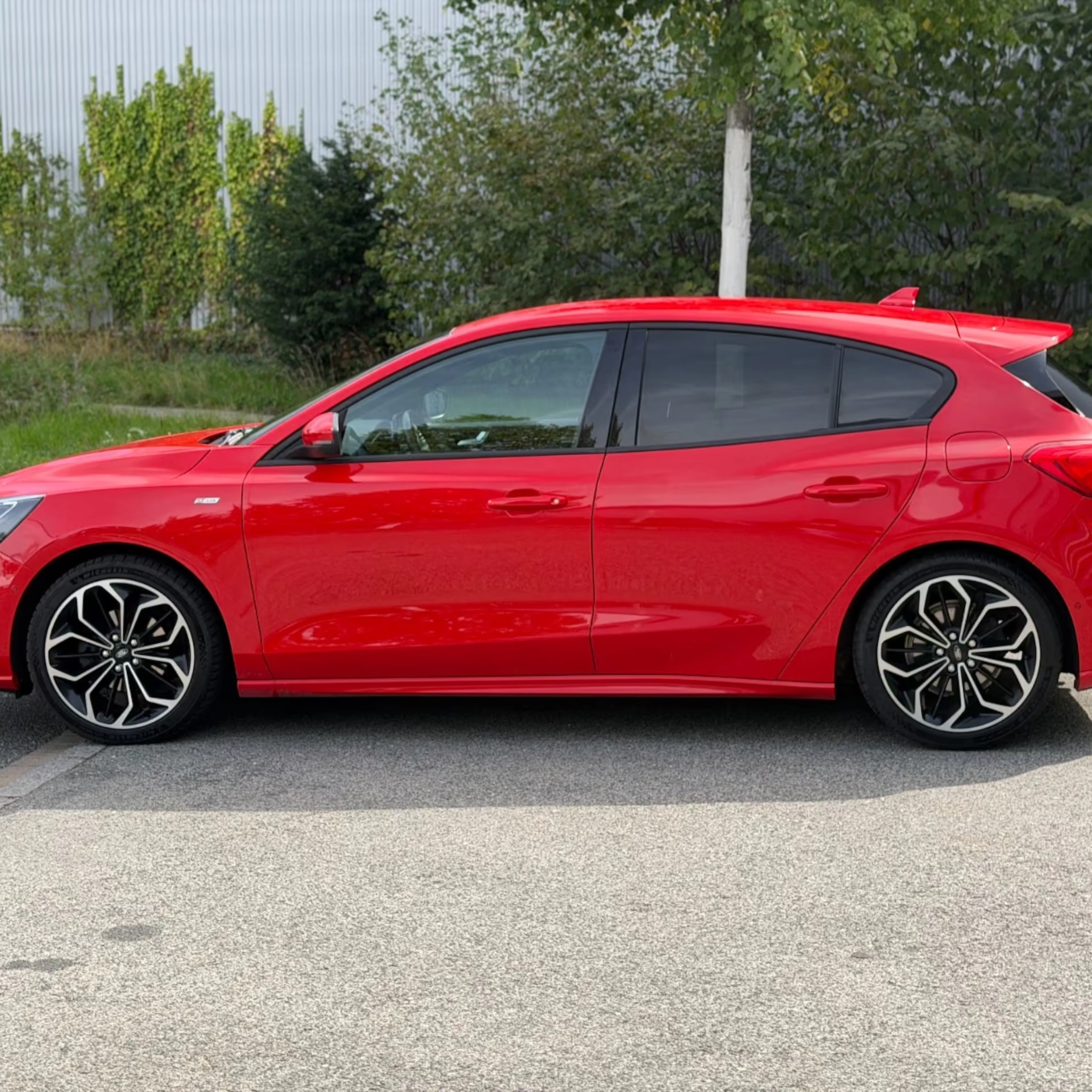 Ein roter Ford Focus steht auf einer befestigten Fläche.