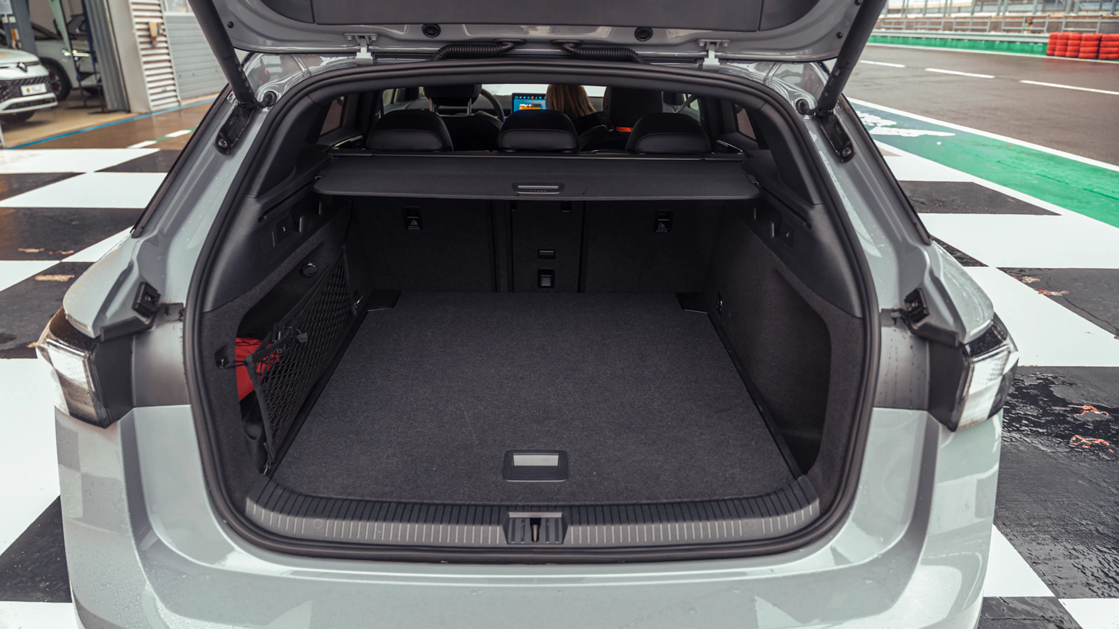 Geöffneter Kofferraum des VW ID.7 Tourer GTX mit Laderaumabdeckung und umgeklappter Rückbank.