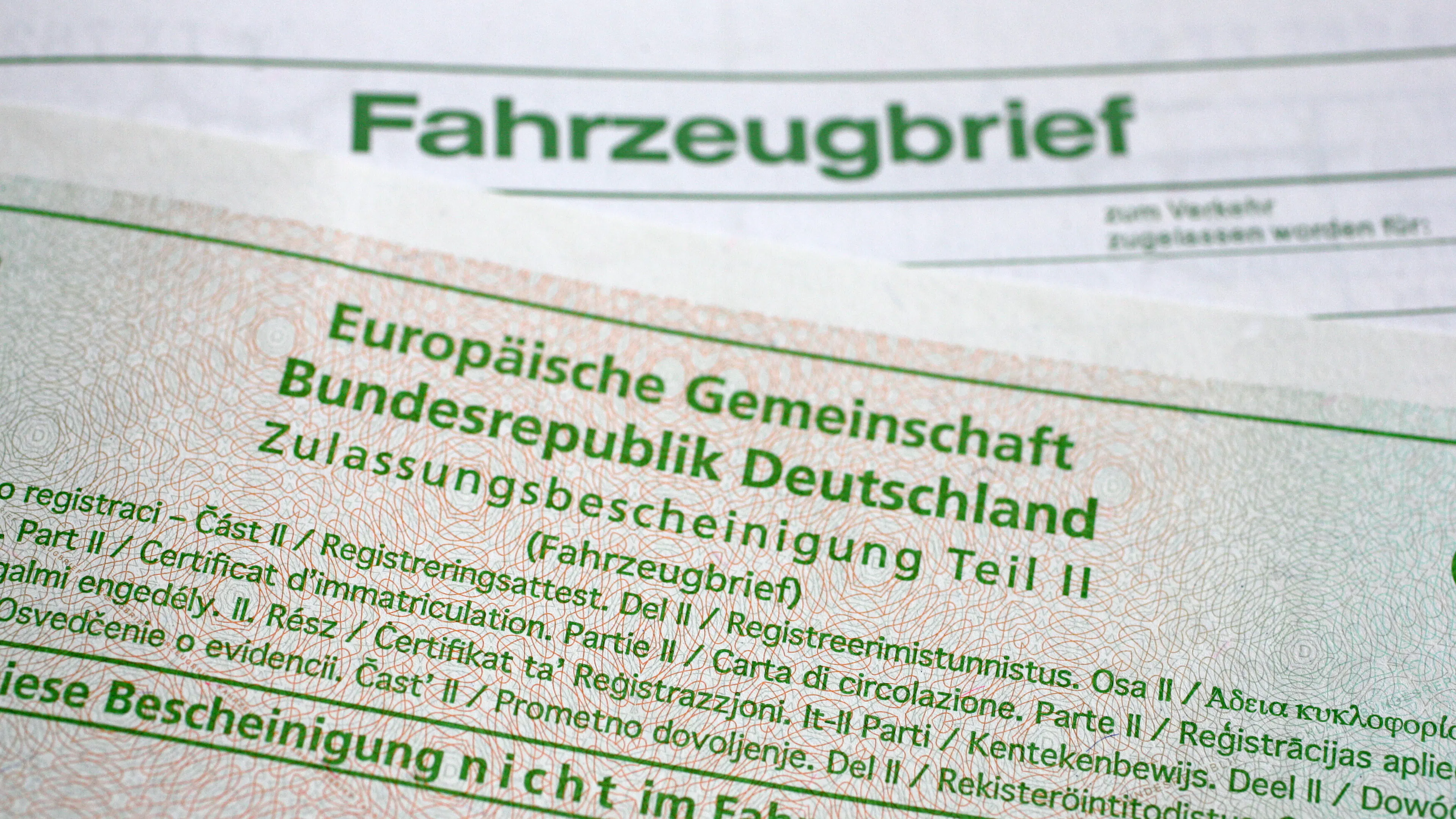 Ein alter Fahrzeugbrief liegt unter einer neuen Zulassungsbescheinigung Teil II.