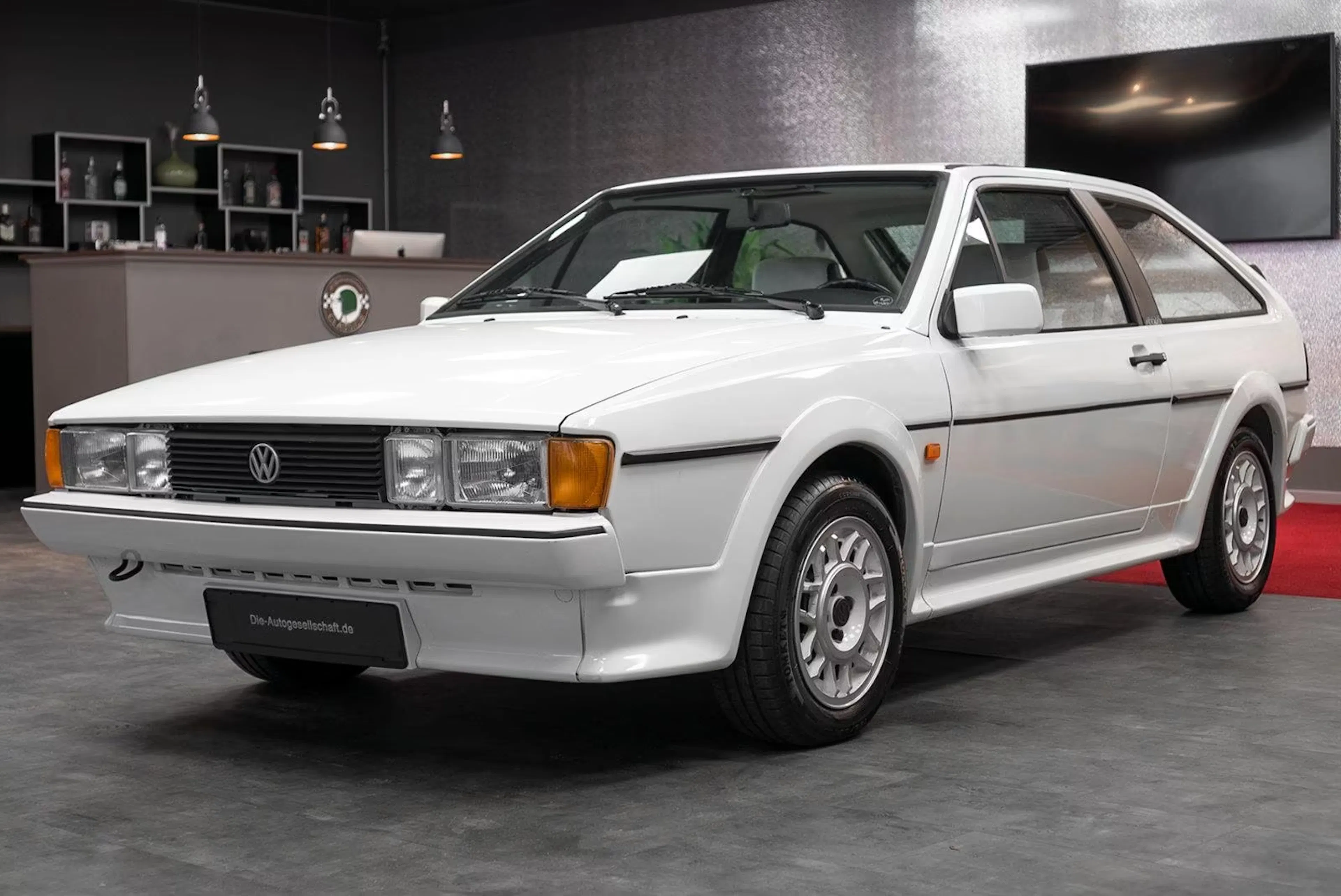 Ein weißer VW Scirocco II steht in einer Werkstatt.