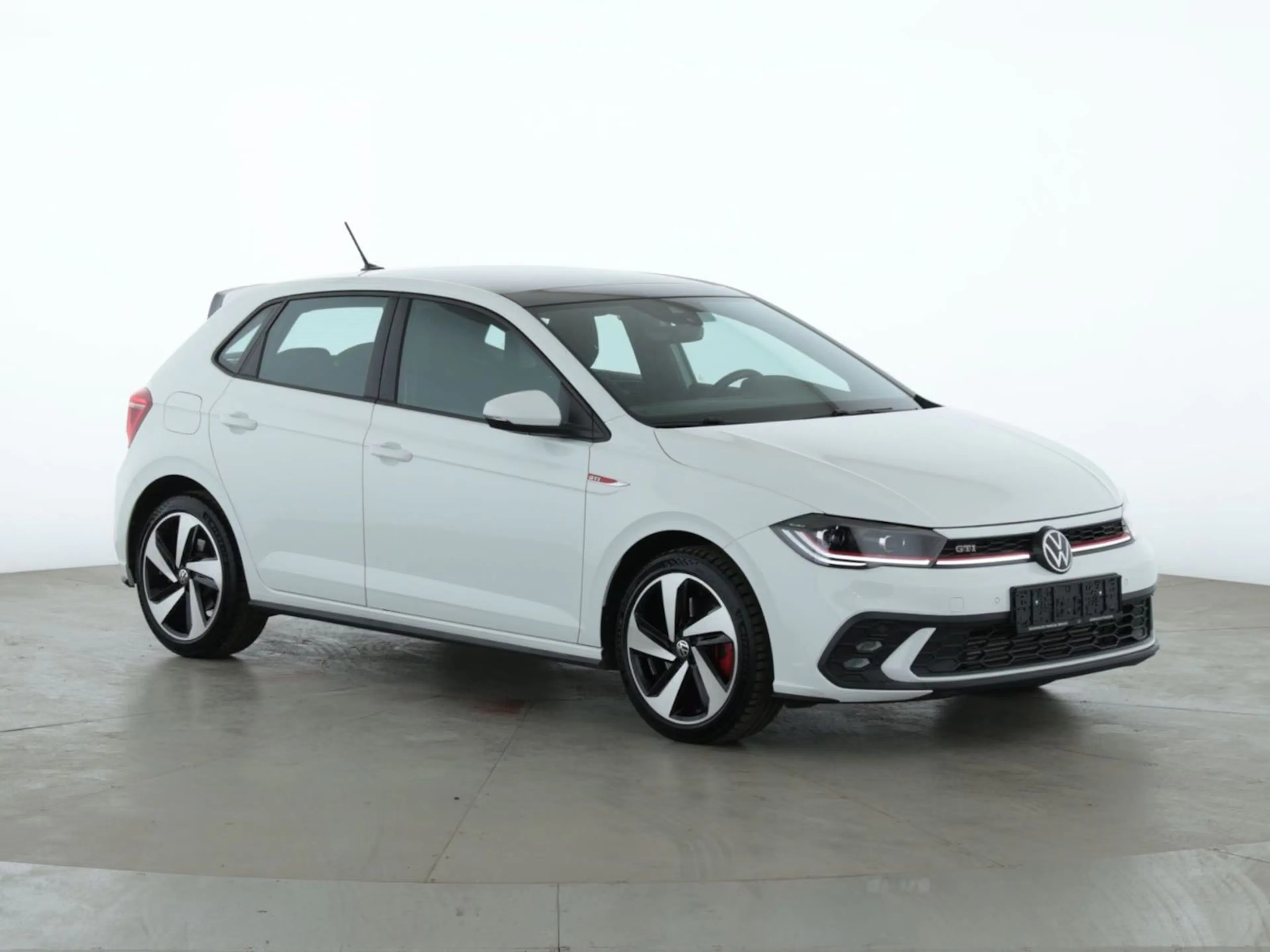 Ein weißer VW Polo GTI steht auf einer Präsentationsfläche.