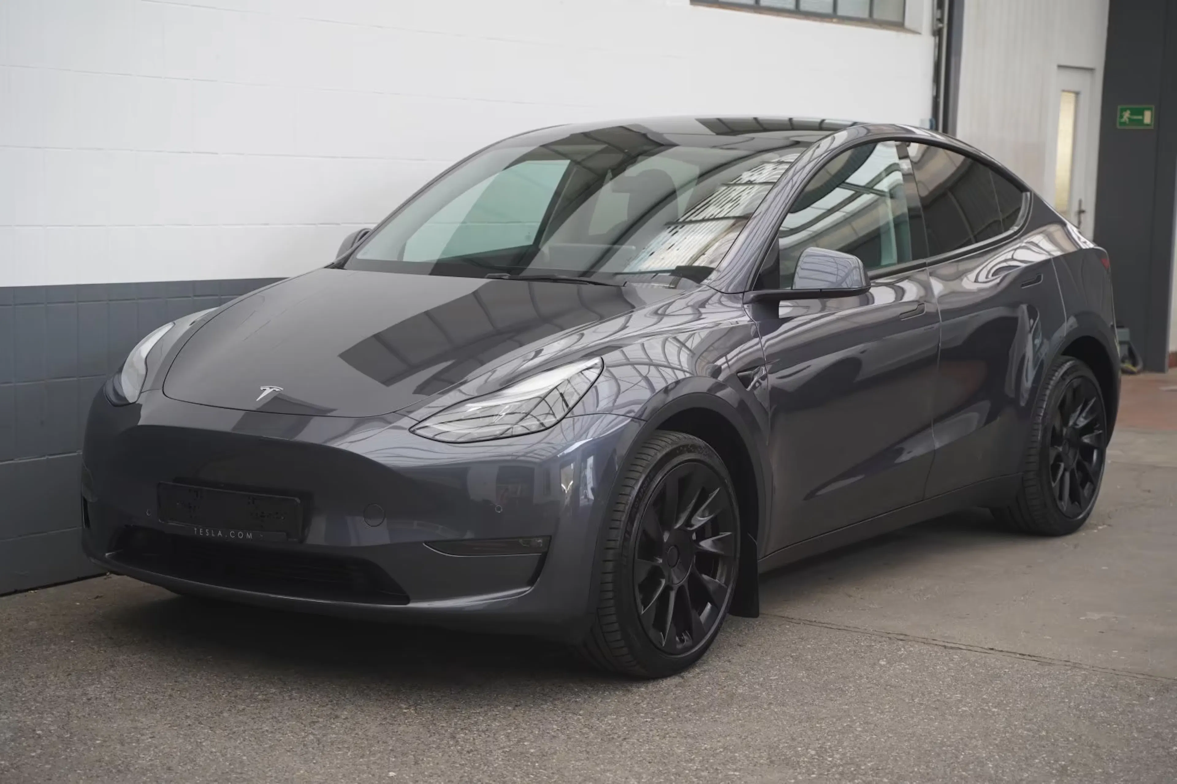 Ein dunkelgrauer Tesla steht auf einer Verkaufsfläche.