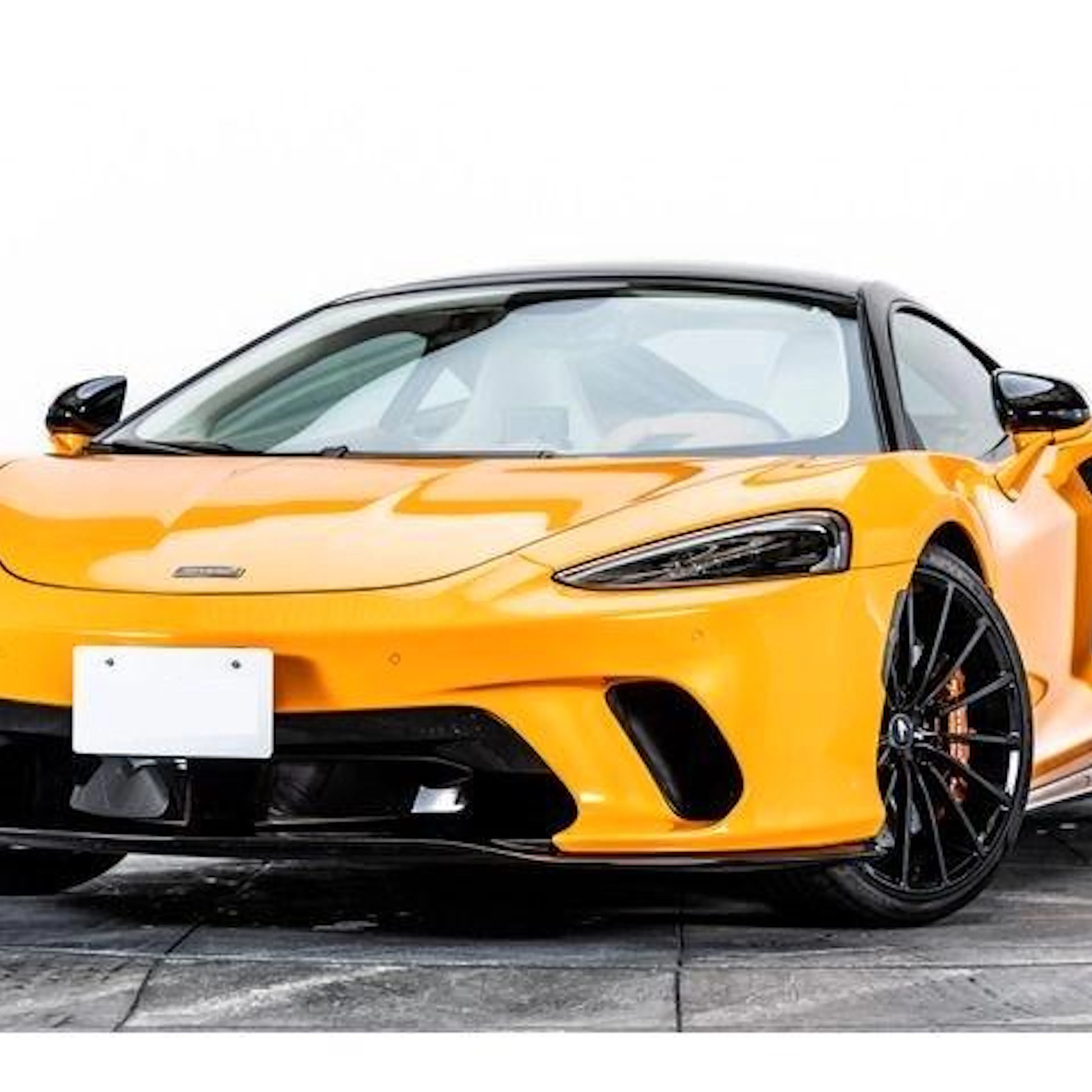 Gelber McLaren GT vor weißer Wand