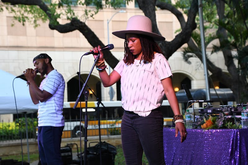 The Reminders, Big Samir and Aja Black, performing on stage at the Hawaii State Art Museum. 
