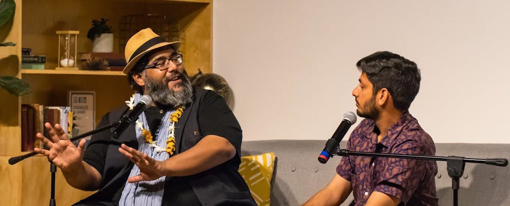Abdul-Rehman Malik and curator, Asad Ali Jafri, sitting on a couch and talking in front of an audience.