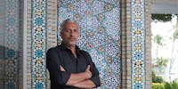 Artist Mohammah Kazem standing in front of the tiled wall on the Dining Lanai at Shangri La.