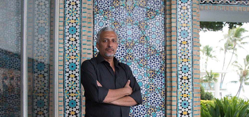 Artist Mohammah Kazem standing in front of the tiled wall on the Dining Lanai at Shangri La.