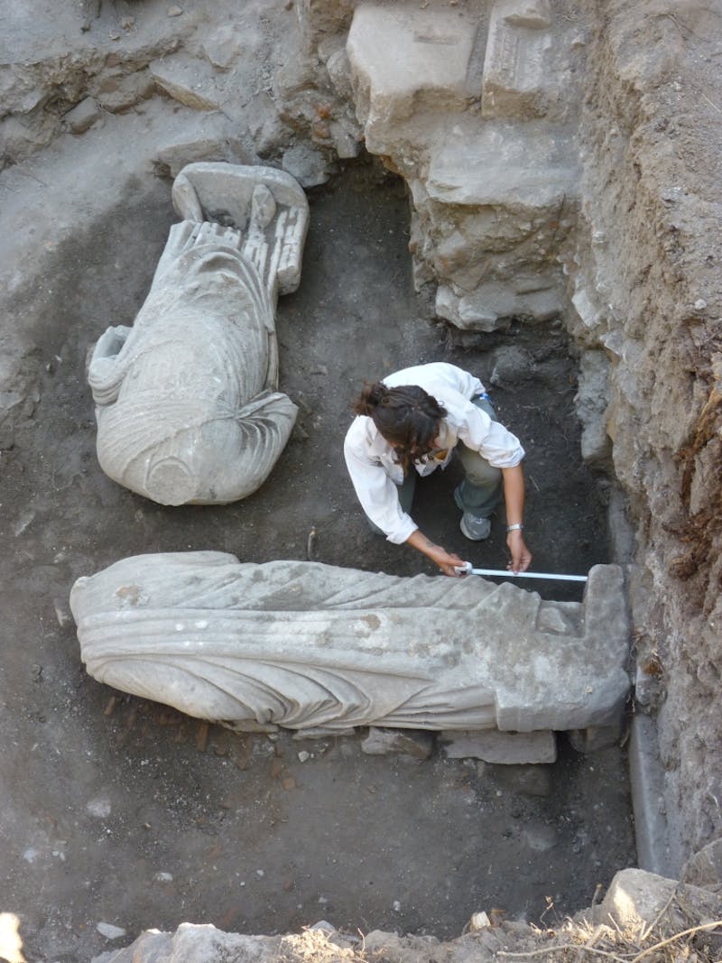 Excavator Austen Di Pinto (New York University Institute of Fine Arts) measuring the location of one of the Roman portrait statues just before lifting from the trench. (Photo: Ian Cartwright.)