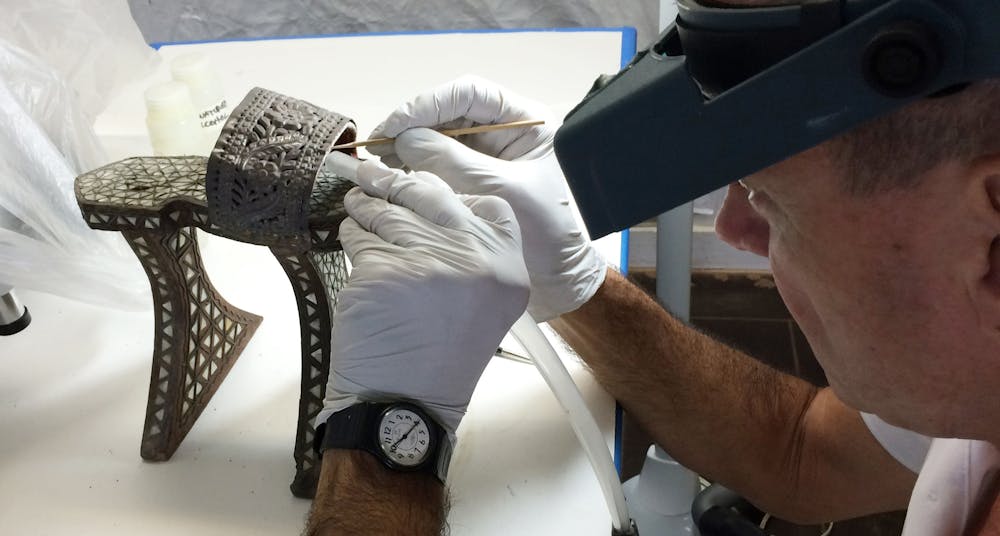 Conservator working on a Hammam shower clog in the conservation lab. 